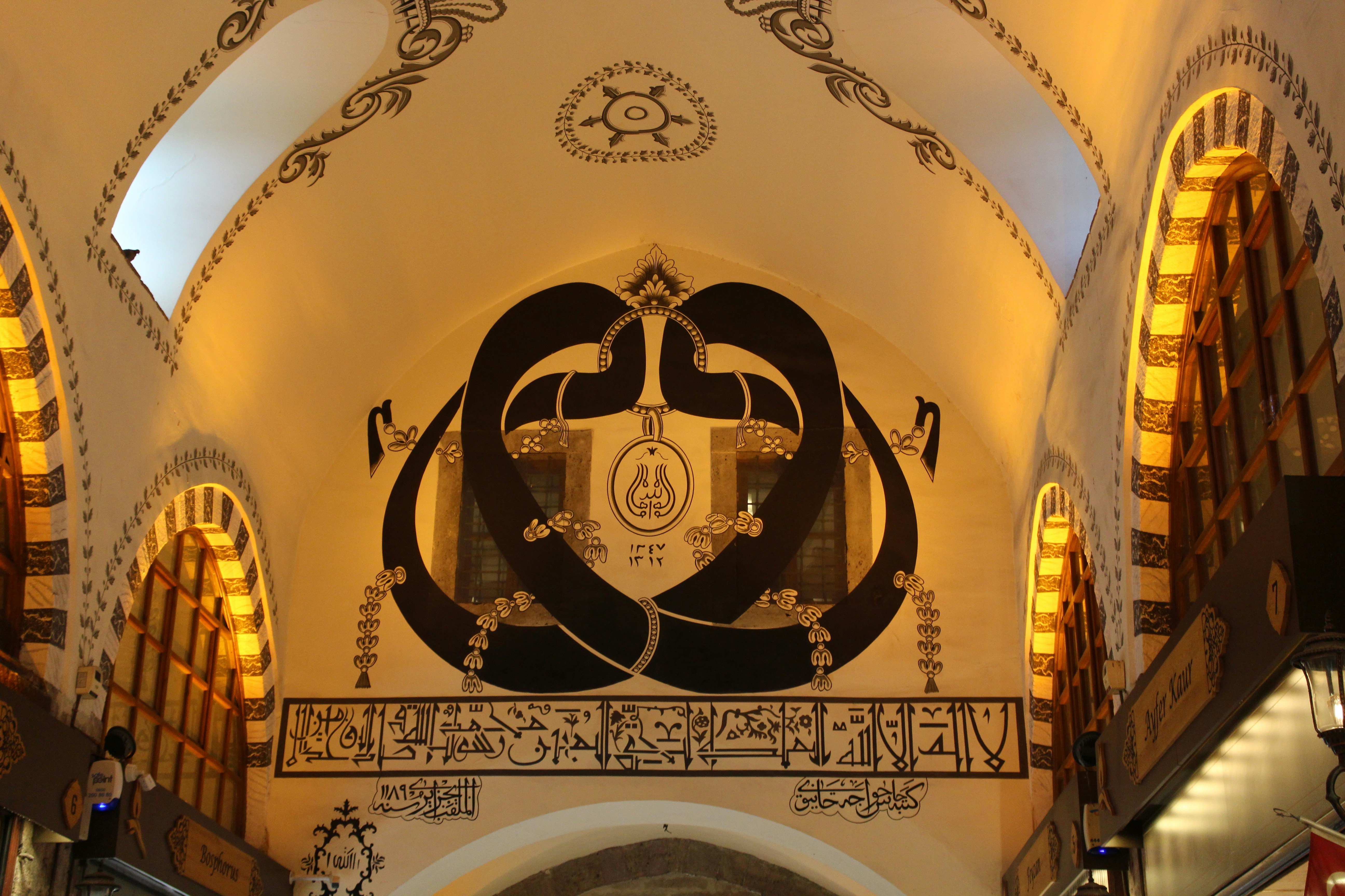 Ornate arched ceiling with intricate dark designs and arched windows