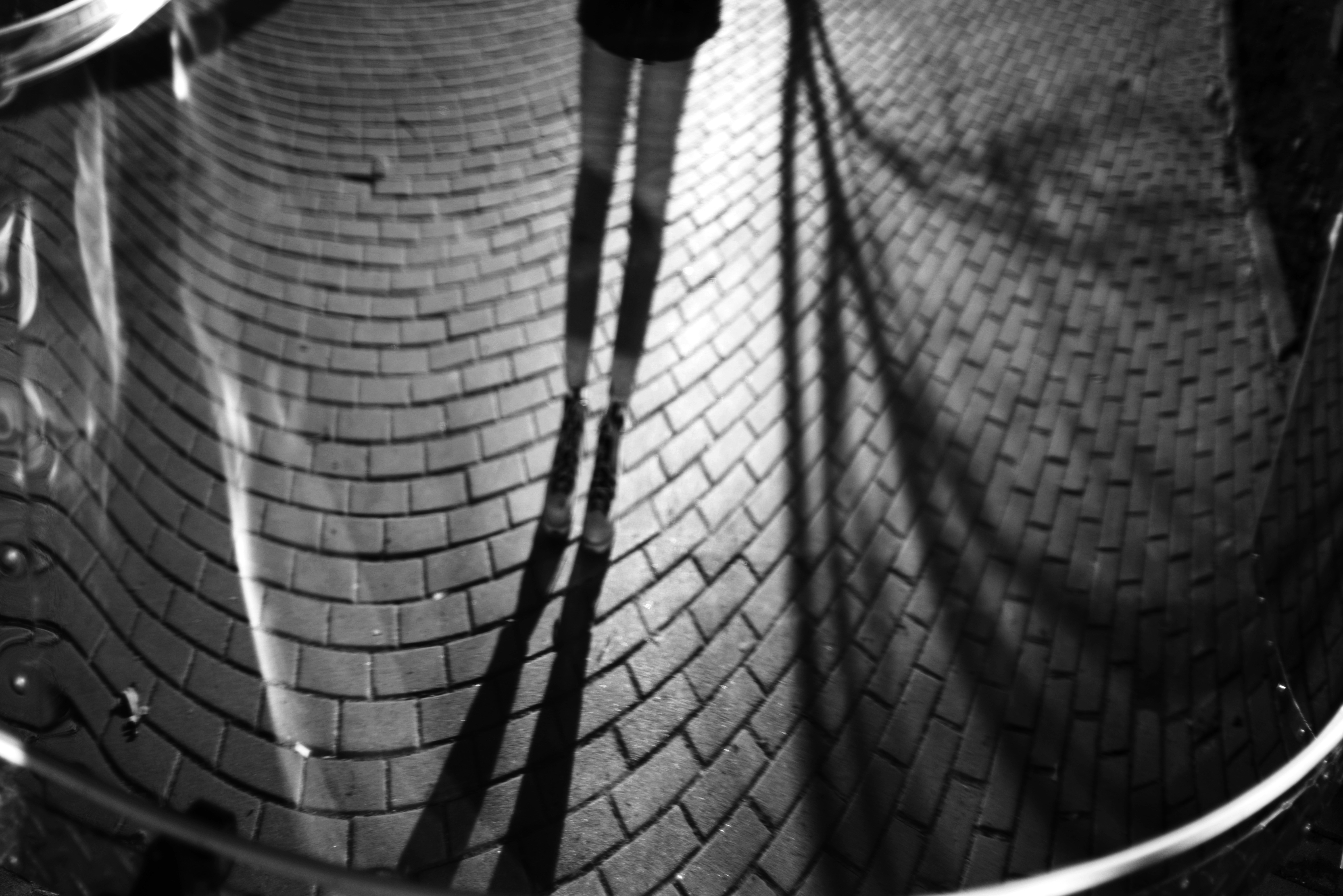 Long shadows stretch across a brick pathway at night.