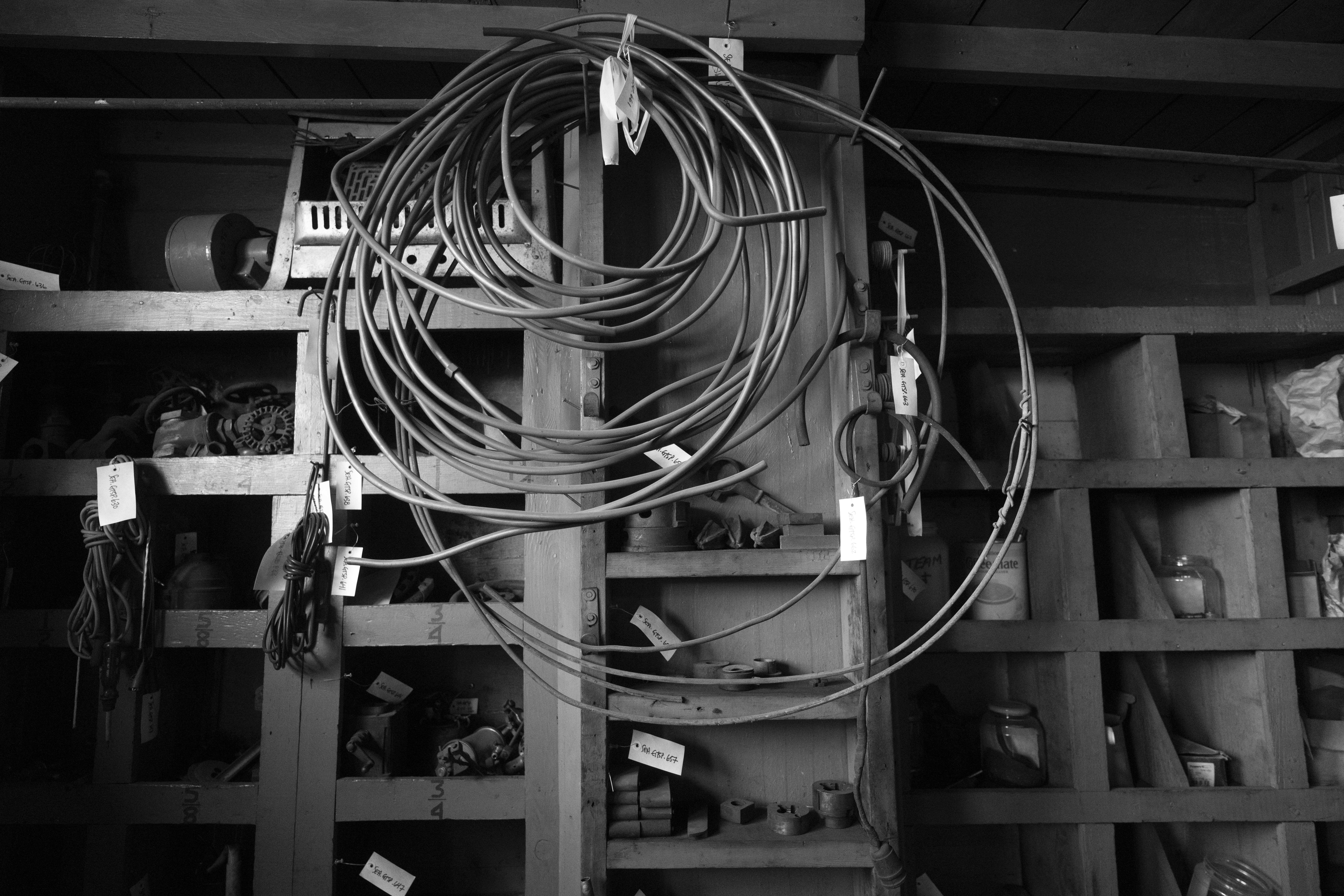 Cables enrollados cuelgan de una estantería en un taller.