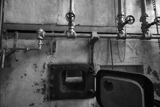 Industrial pipes and valves above an open furnace door.