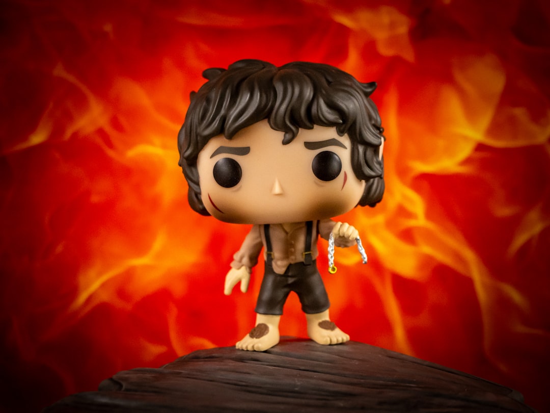 A frodo baggins funko pop against a fiery background.