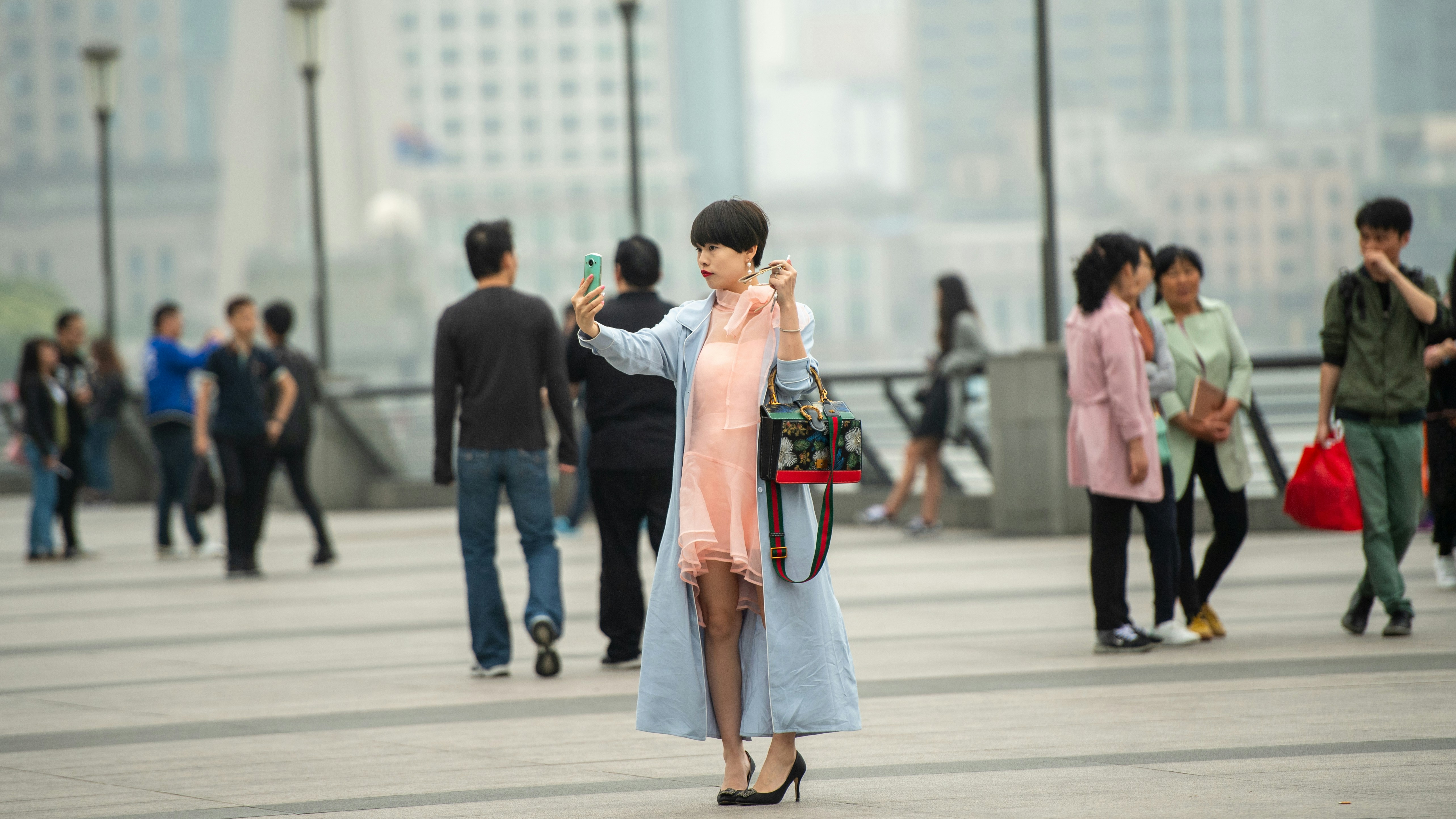 Woman taking a selfie with city buildings in background