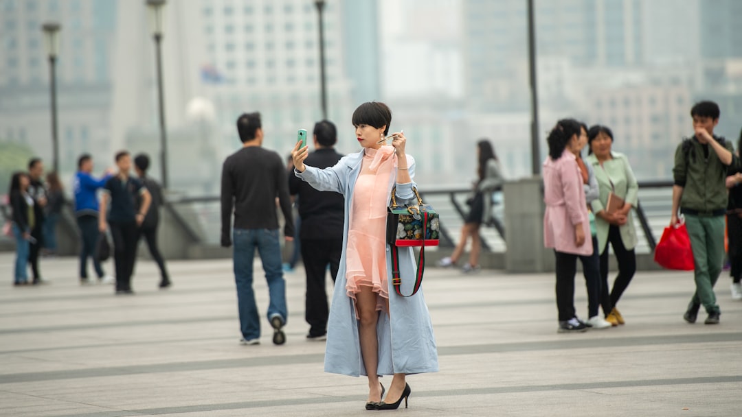 Tourist using phone along Shanghai waterfront