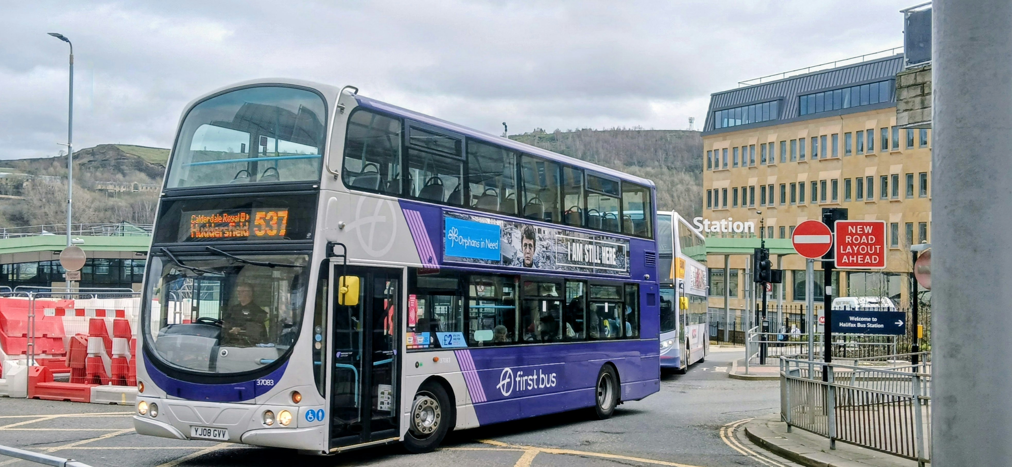 Purple and white double-decker bus on city street