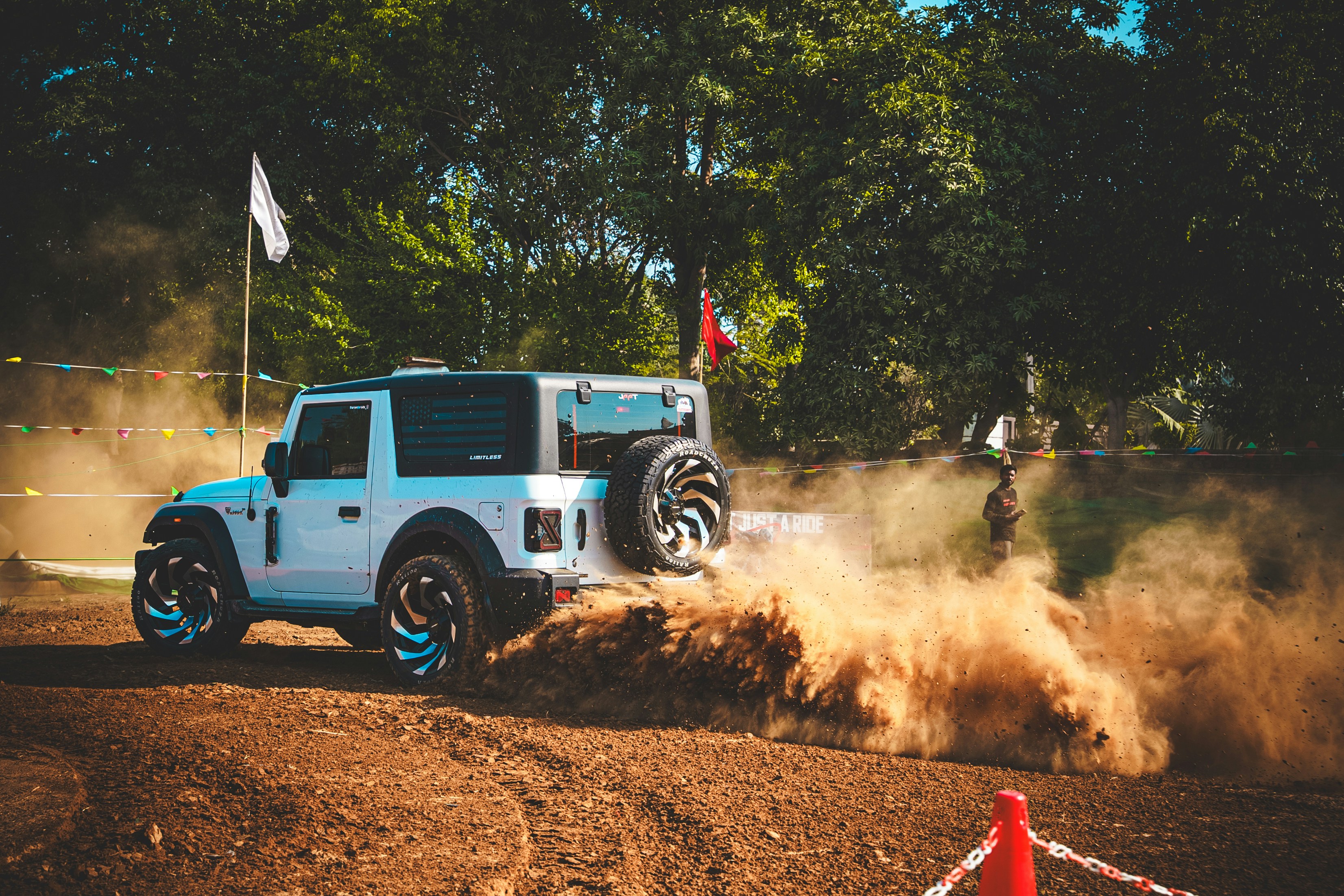 Véhicule tout-terrain blanc soulève de la terre sur une piste