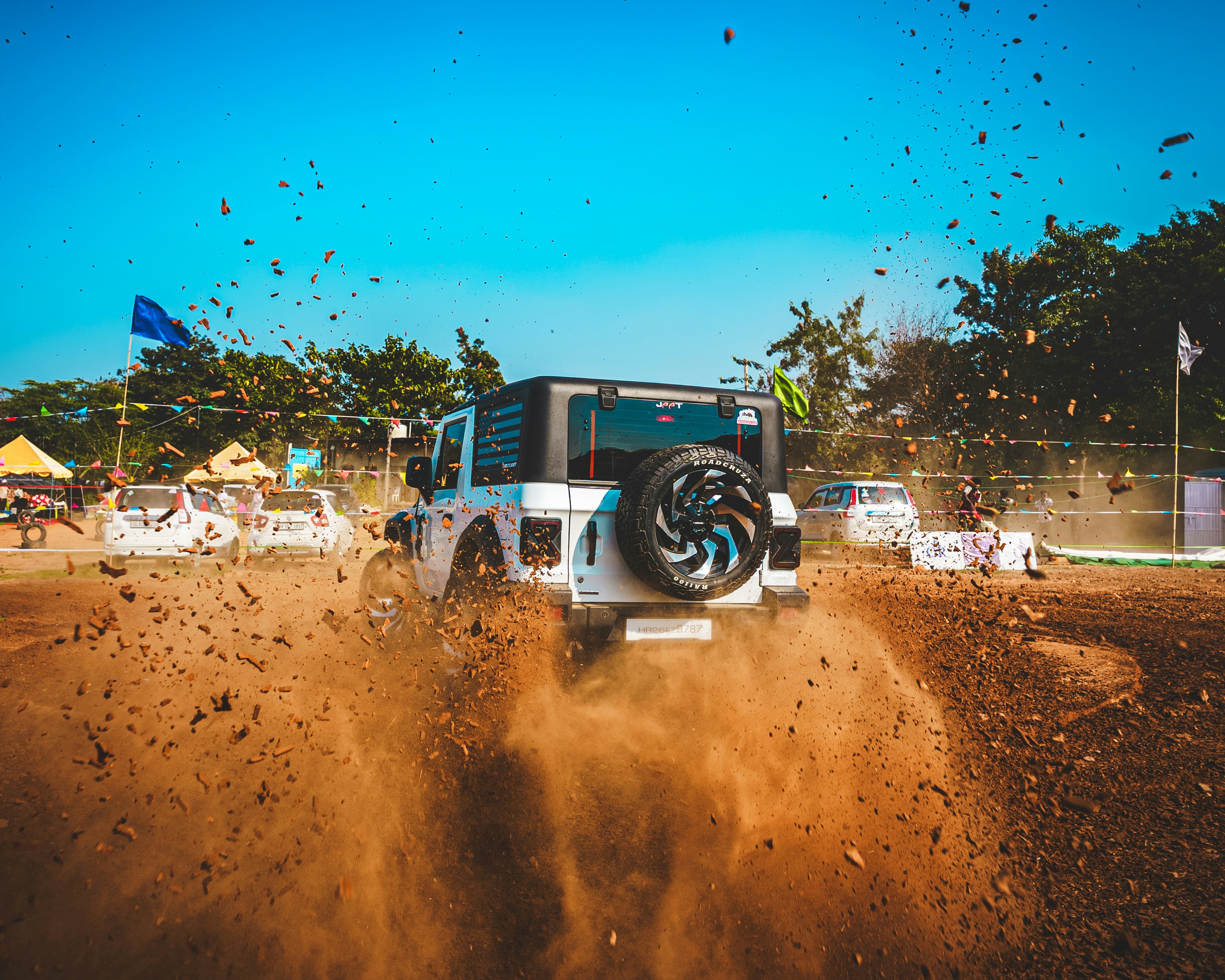 Jeep blanche roulant dans la poussière, soulevant la poussière