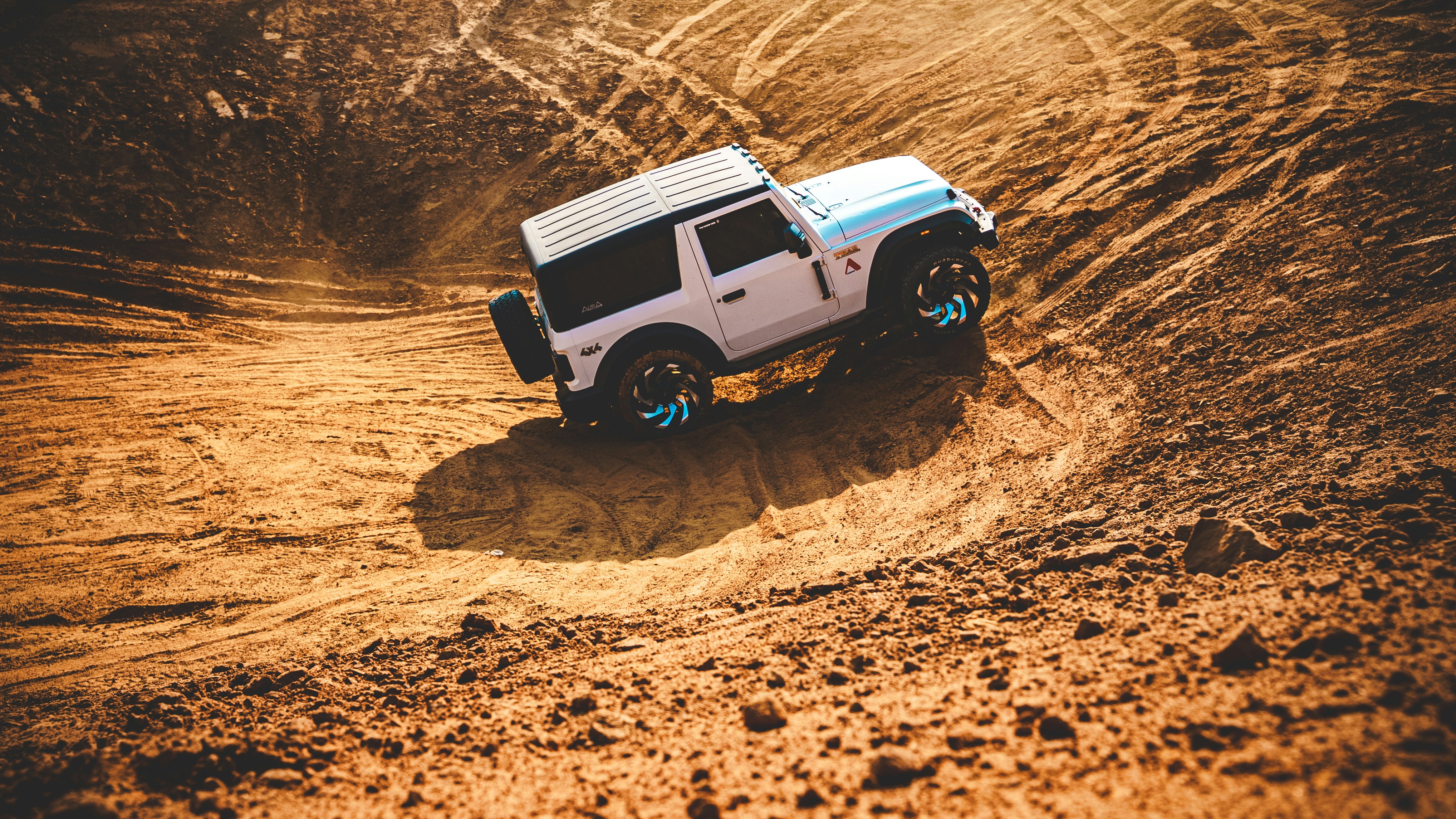 Véhicule tout-terrain blanc roulant sur un sentier de terre.