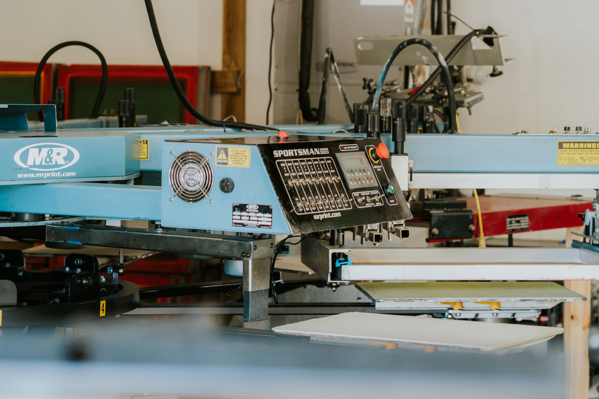 Industrial screen printing machine in a workshop setting.