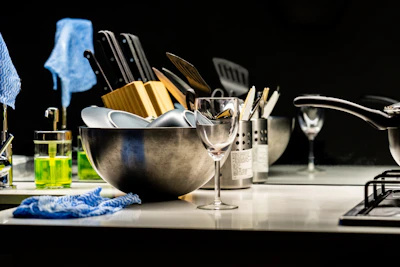 A kitchen sink with dishes and cleaning supplies.