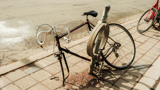 A bicycle locked to a pole on a sidewalk.