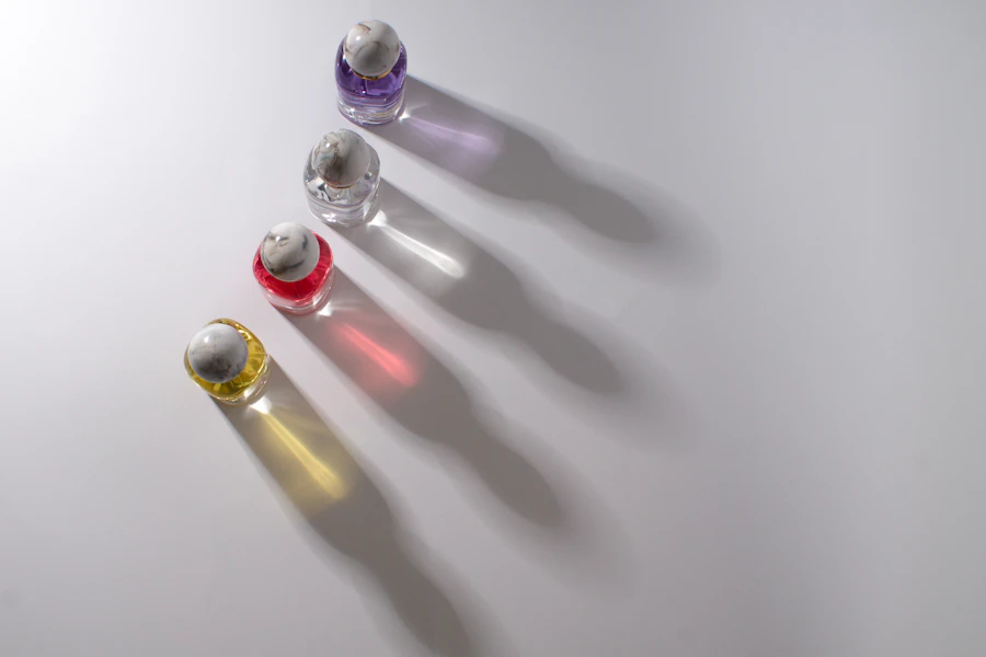 Four small colorful bottles casting shadows on a white surface.