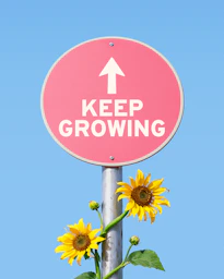 Pink sign with "keep growing" and sunflowers