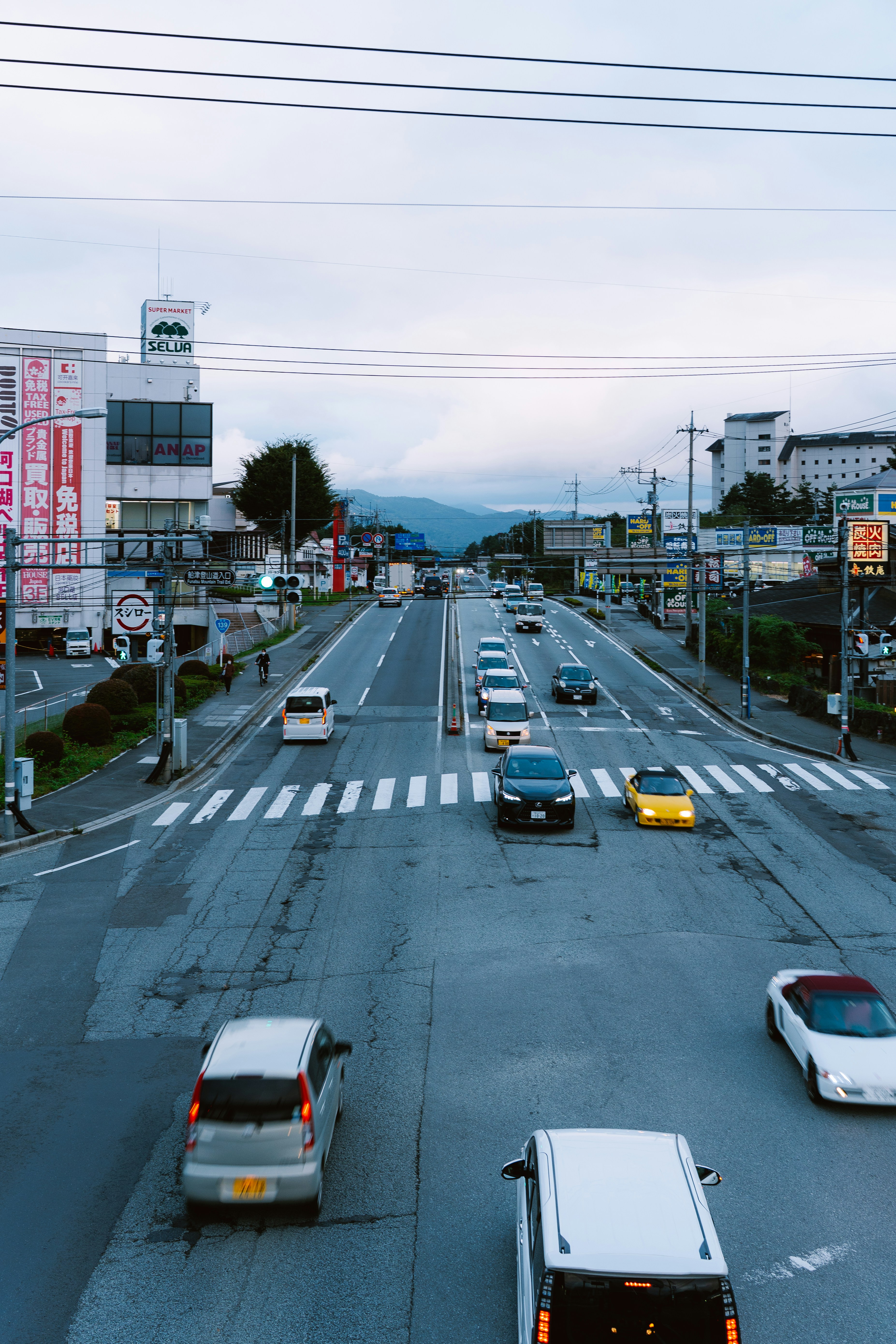 Autos, die auf einer Straße mit Gebäuden und Bergen fahren.