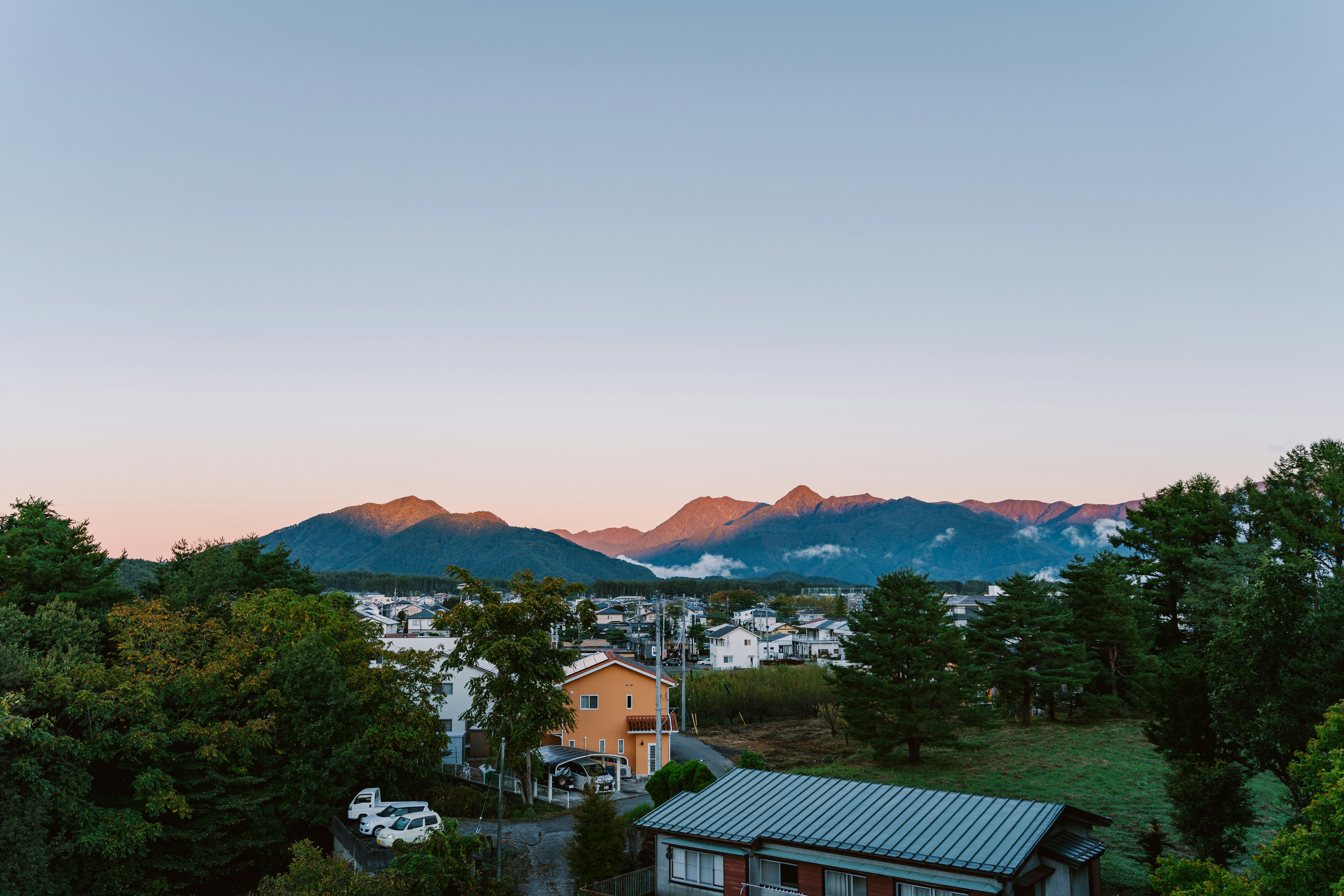 Berglandschaft mit Häusern und Bäumen bei Tagesanbruch
