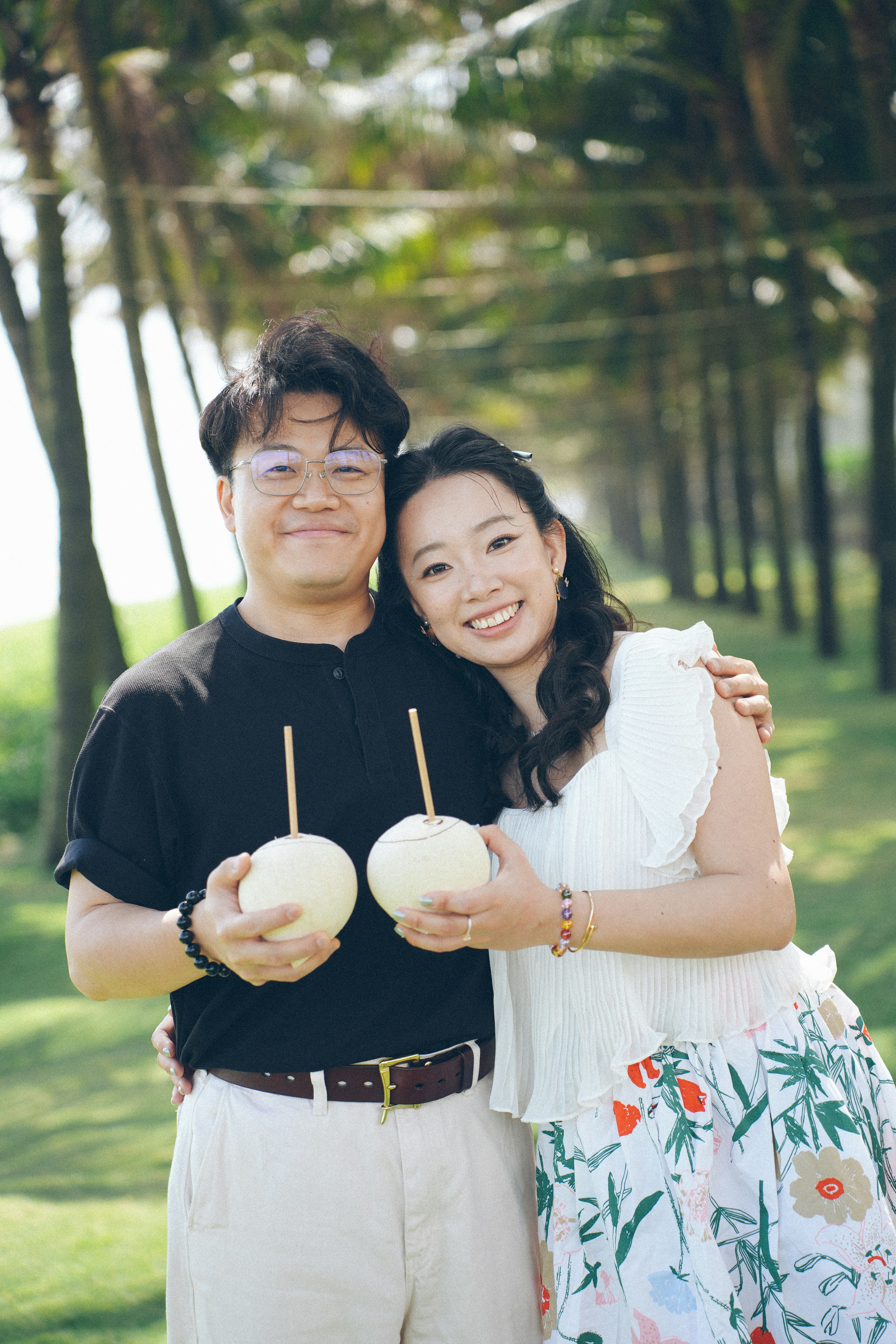 Couple holding coconuts on a tropical beach
