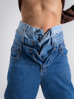 Two pairs of jeans layered on a person.