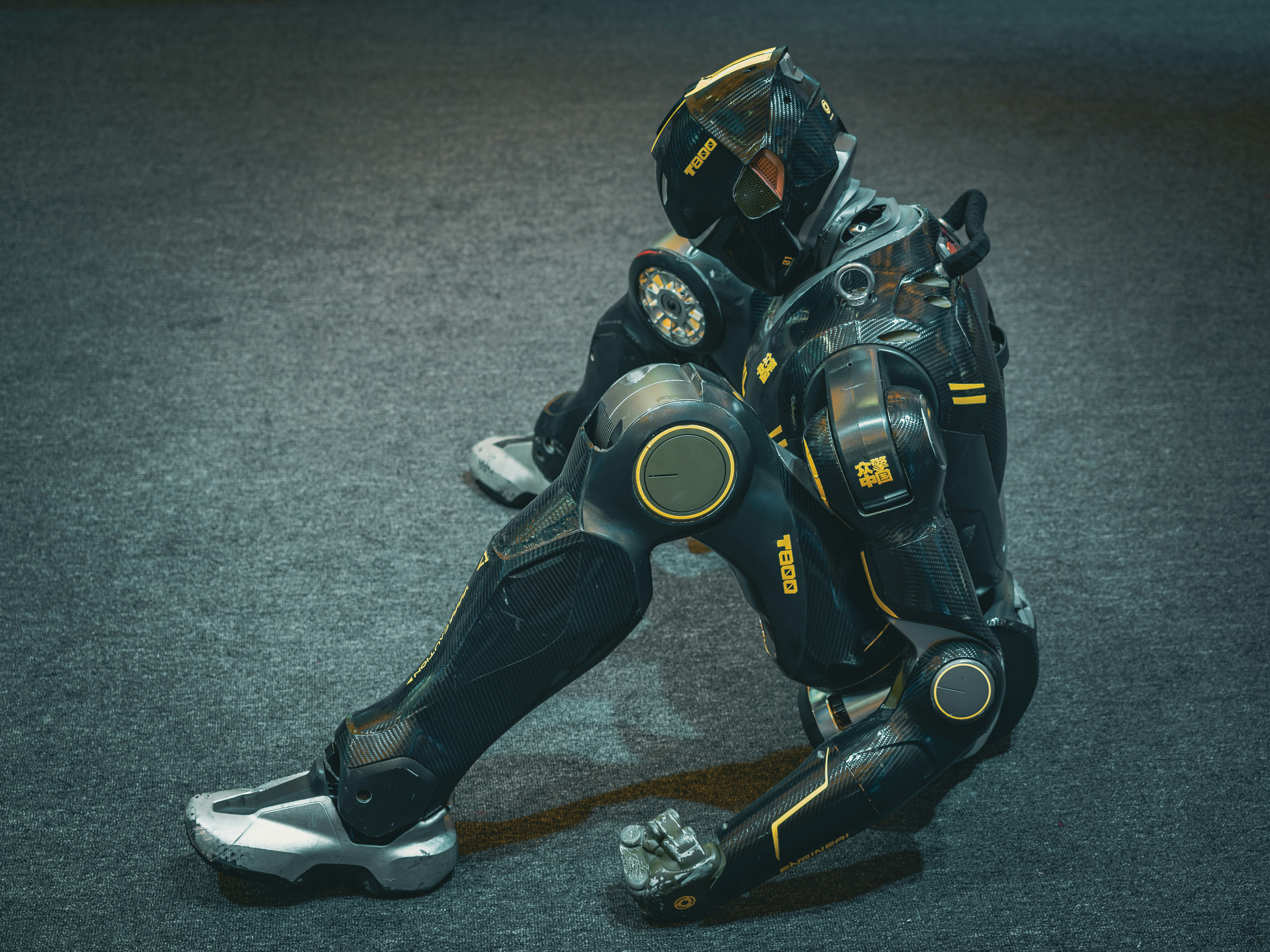 A futuristic robot sits on the floor