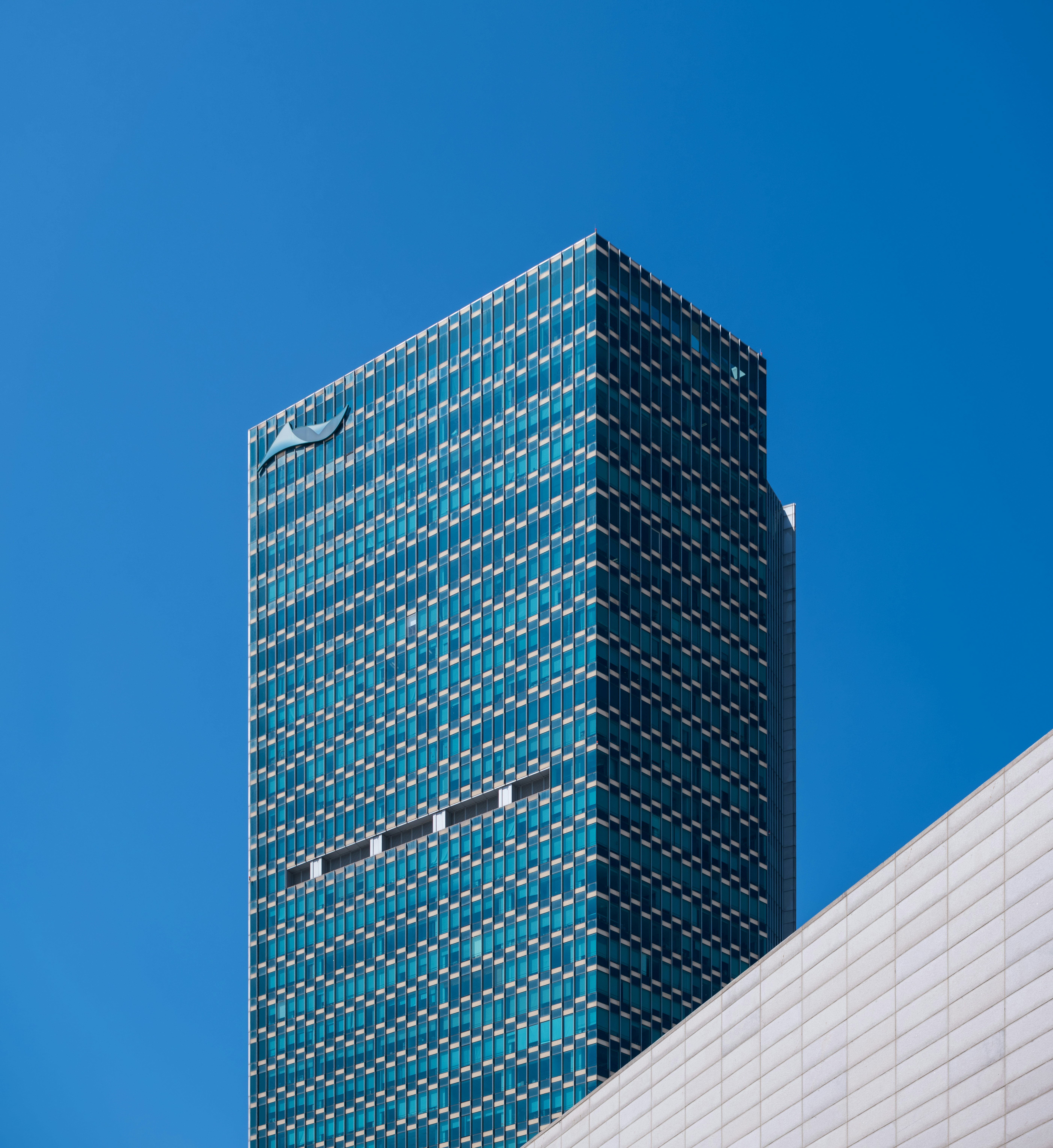 Modern glass skyscraper against a clear blue sky