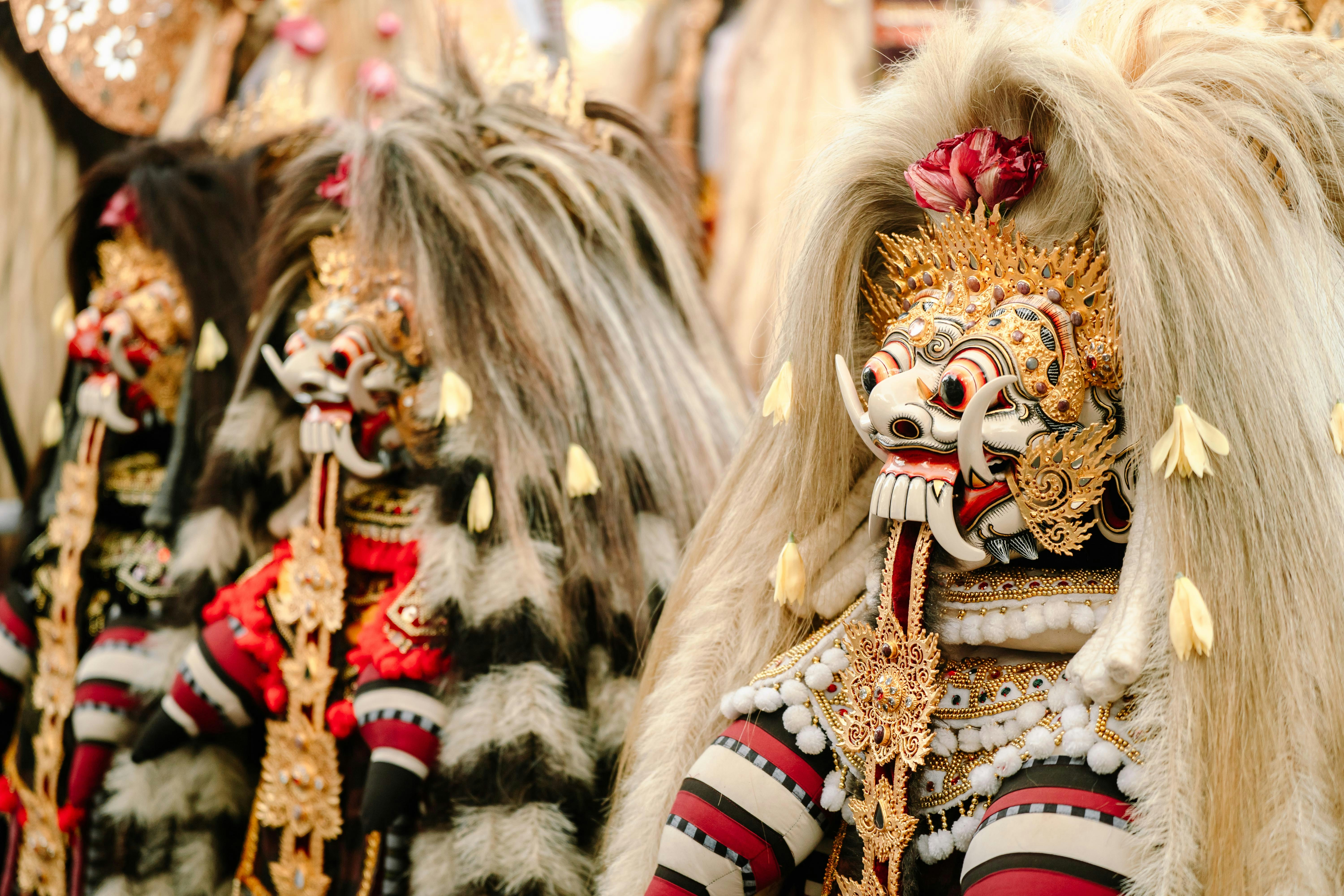 Two ornate balinese barong masks with elaborate headdresses