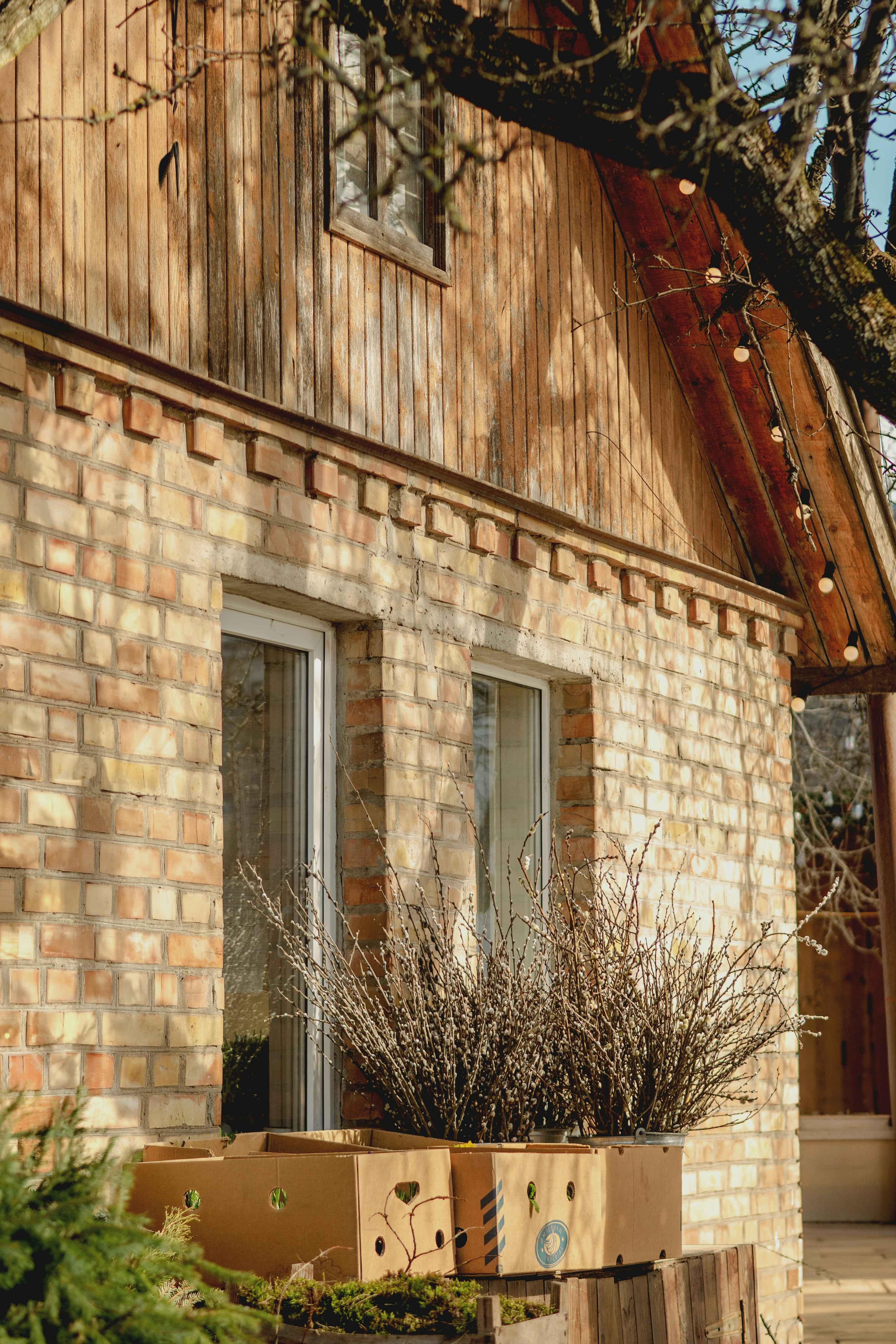 Brick house with wooden accents and potted plants