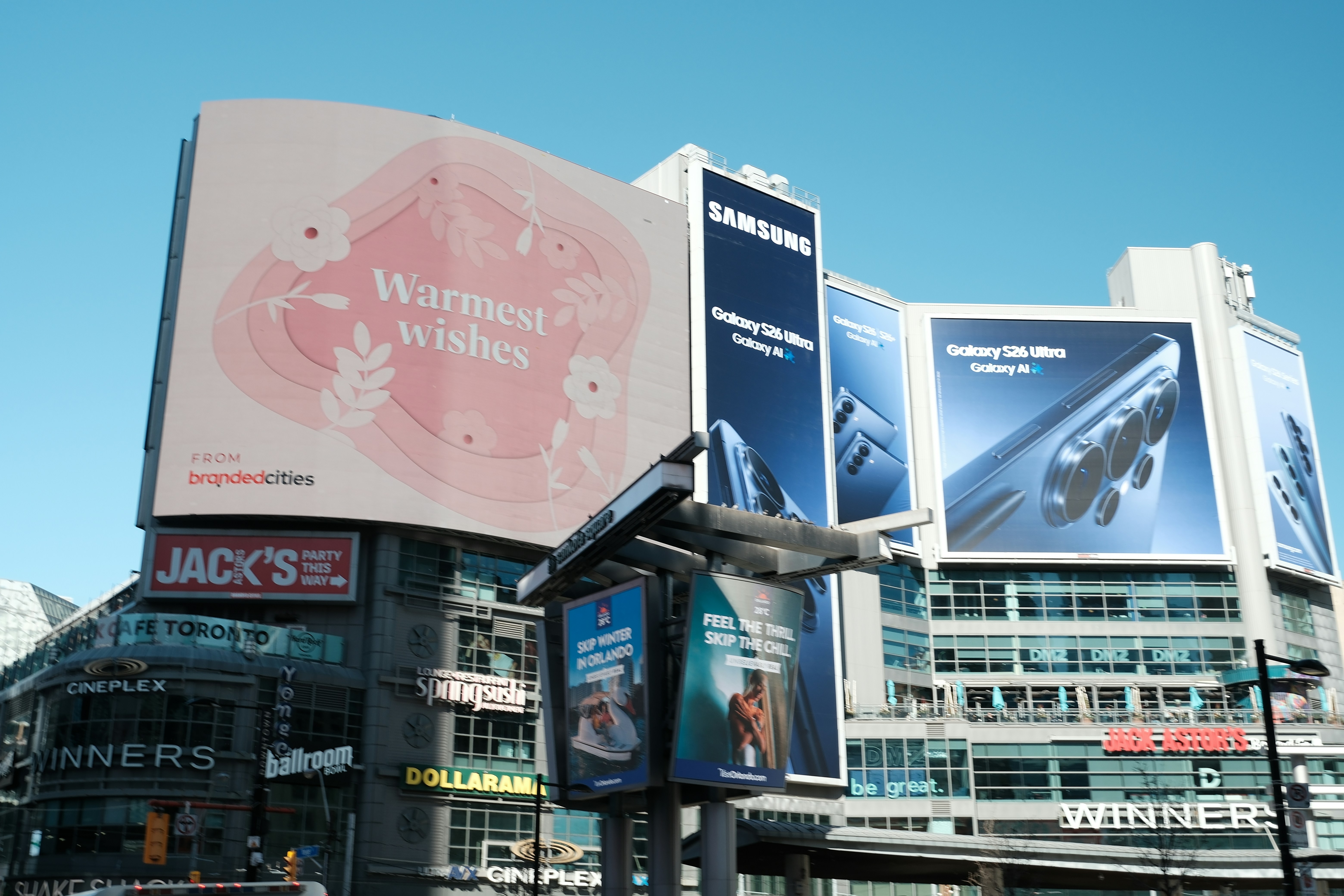 Large digital billboards display advertisements in a city.