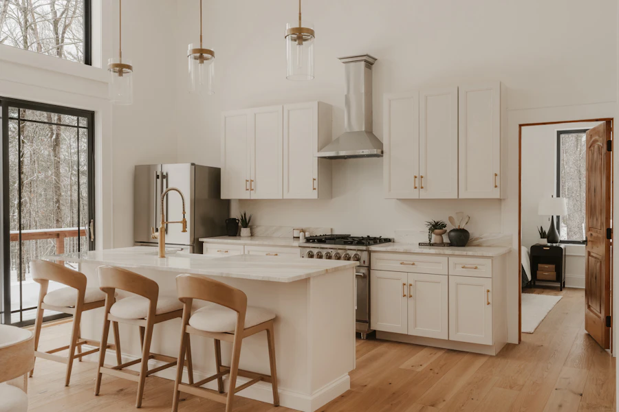Modern white kitchen with a central island and bar stools