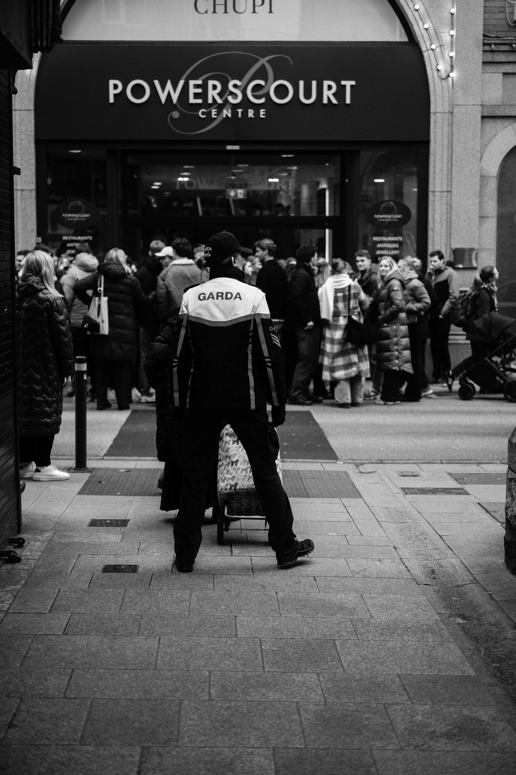 Uniformed security guard positioned outside a building entrance