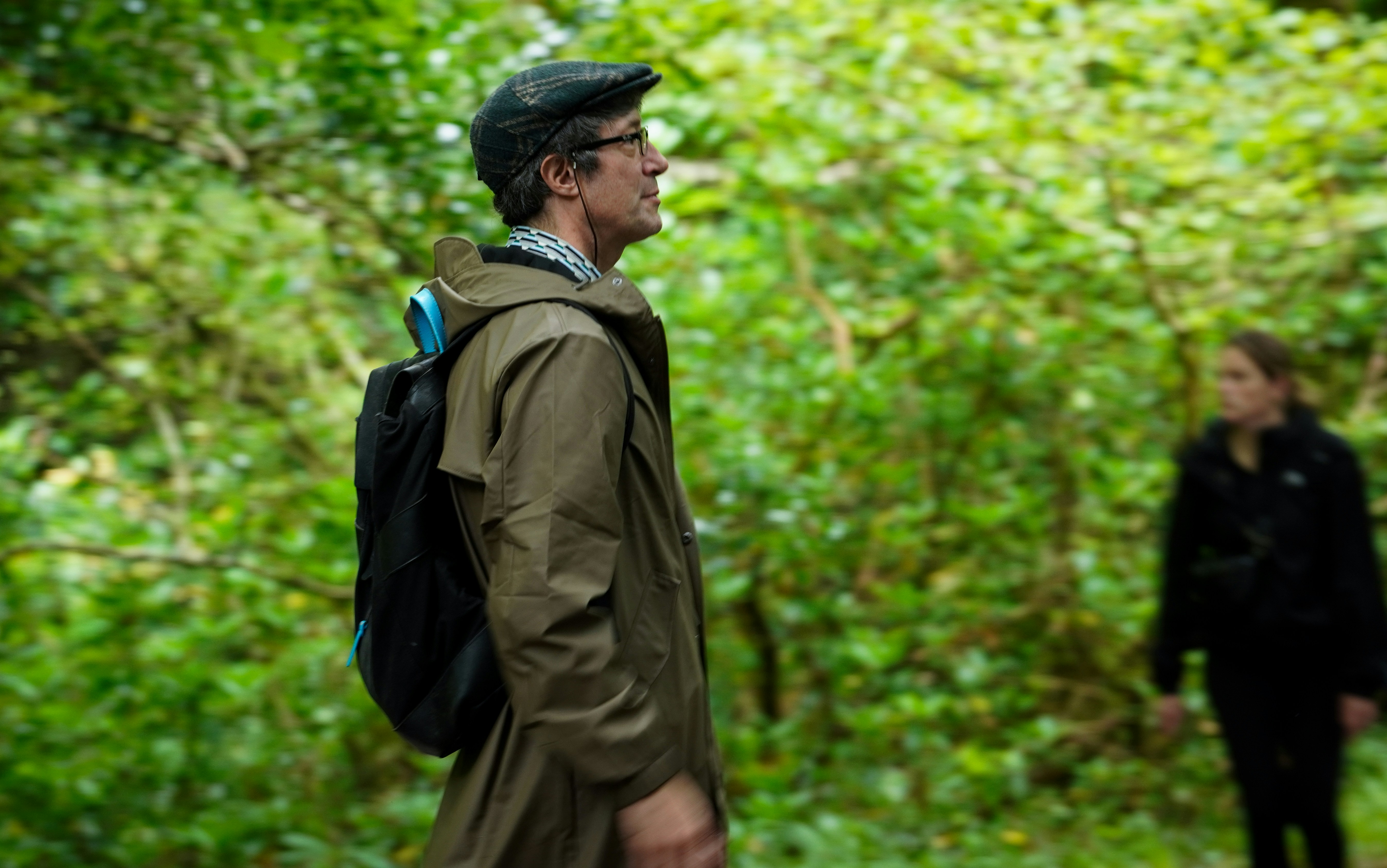 Hiker wearing rain protection in a lush forest