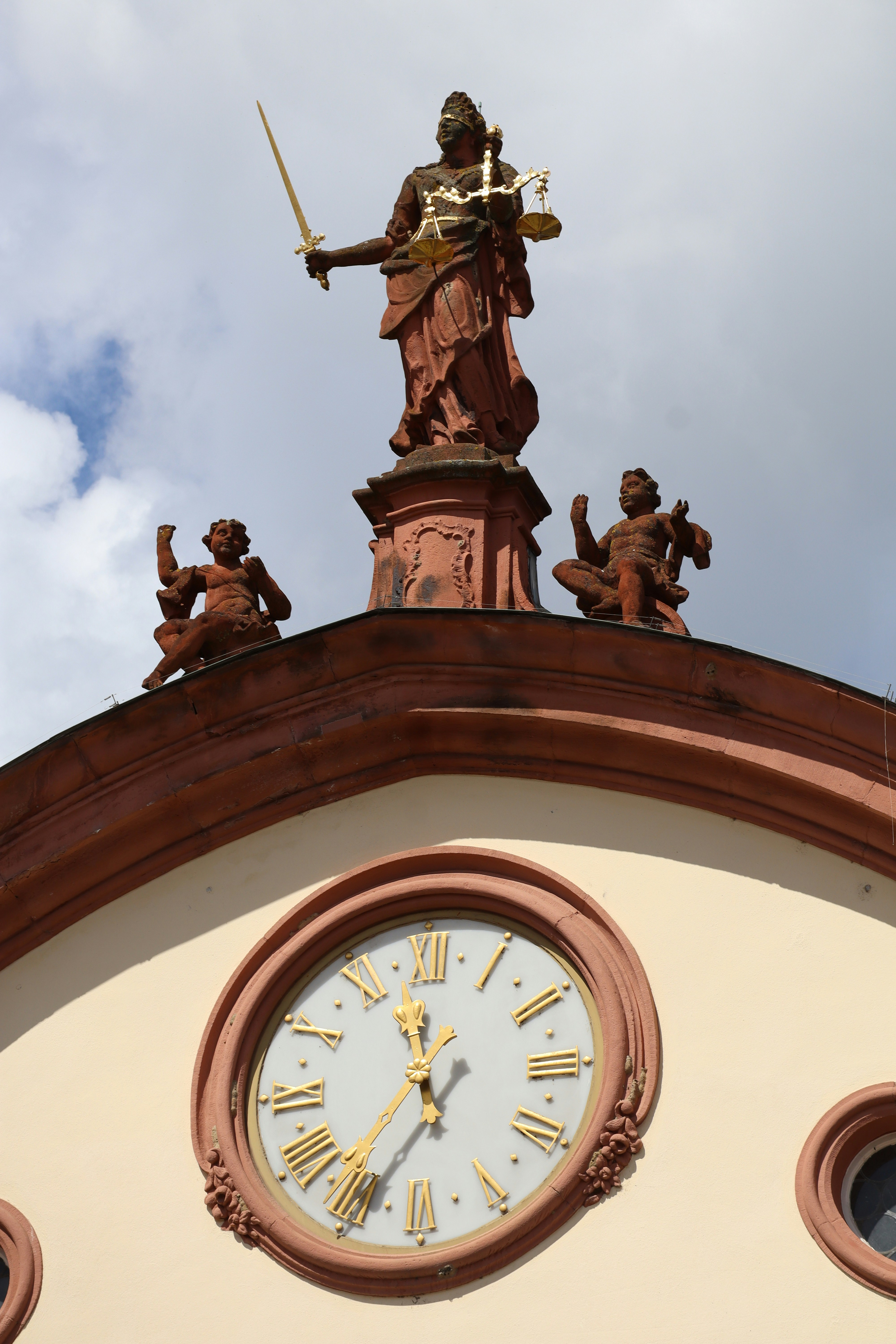 Estatua de la justicia sobre una esfera de reloj