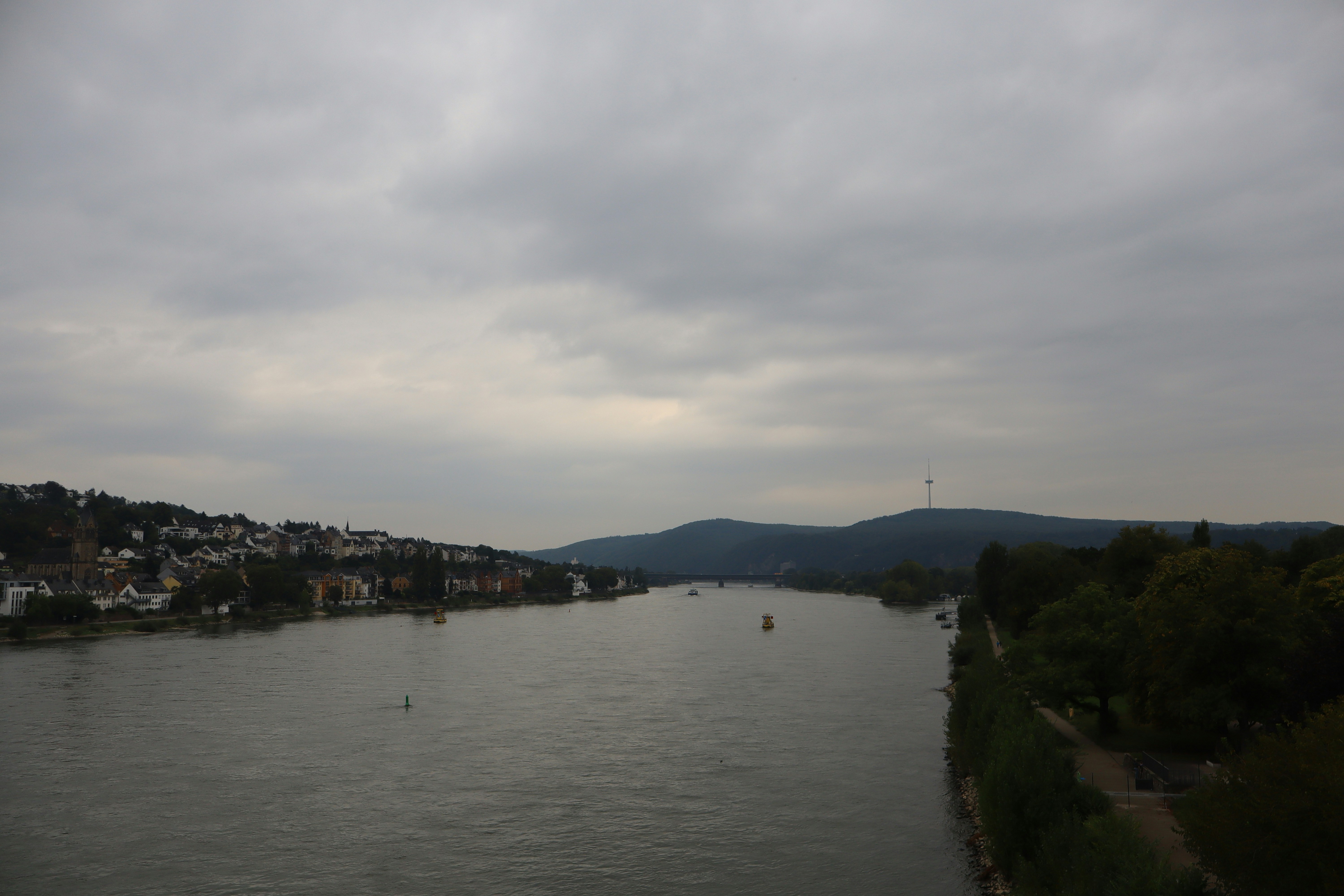 Wide river flowing through a town and hills