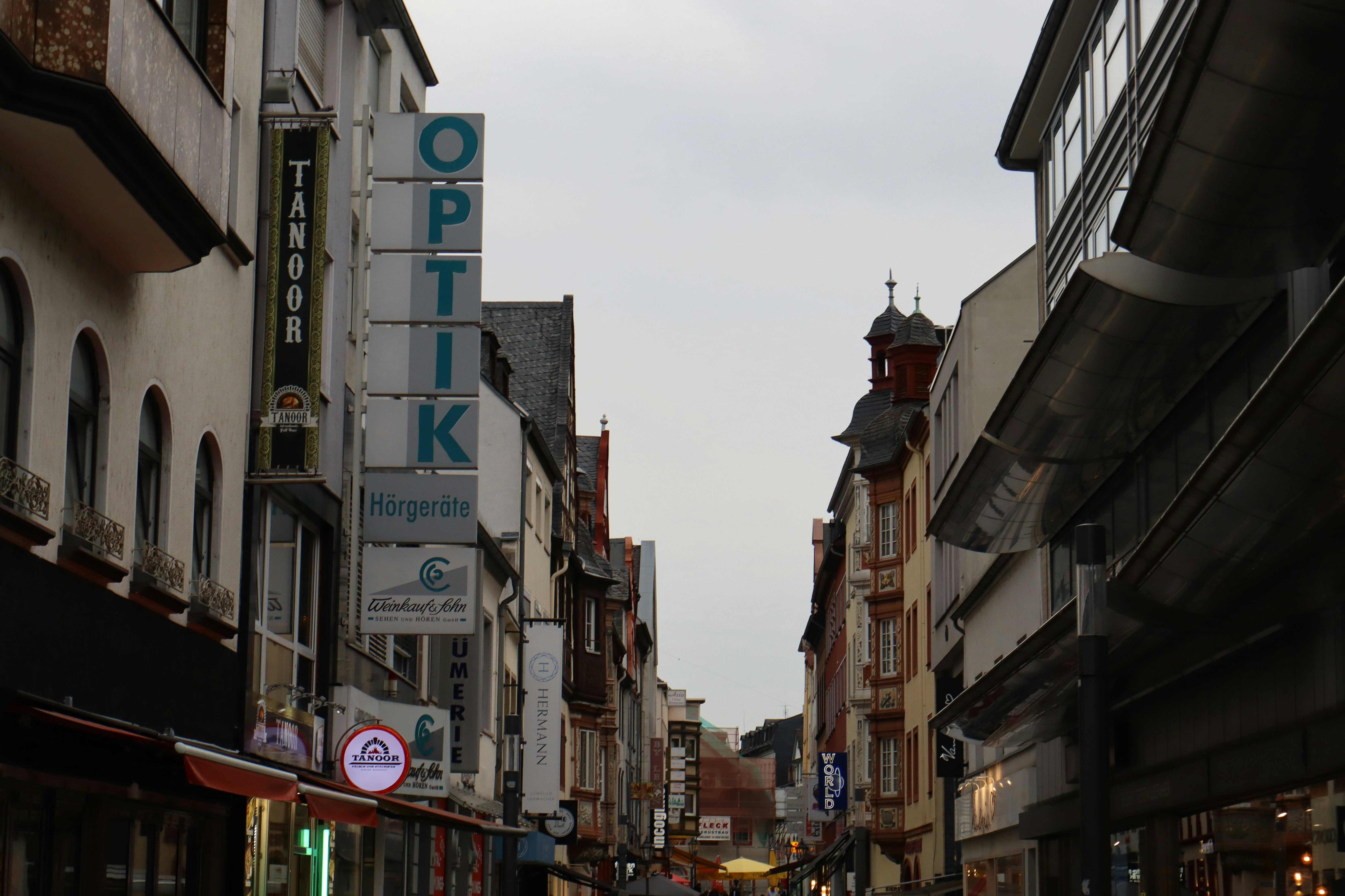 Street view of buildings with an optician sign.