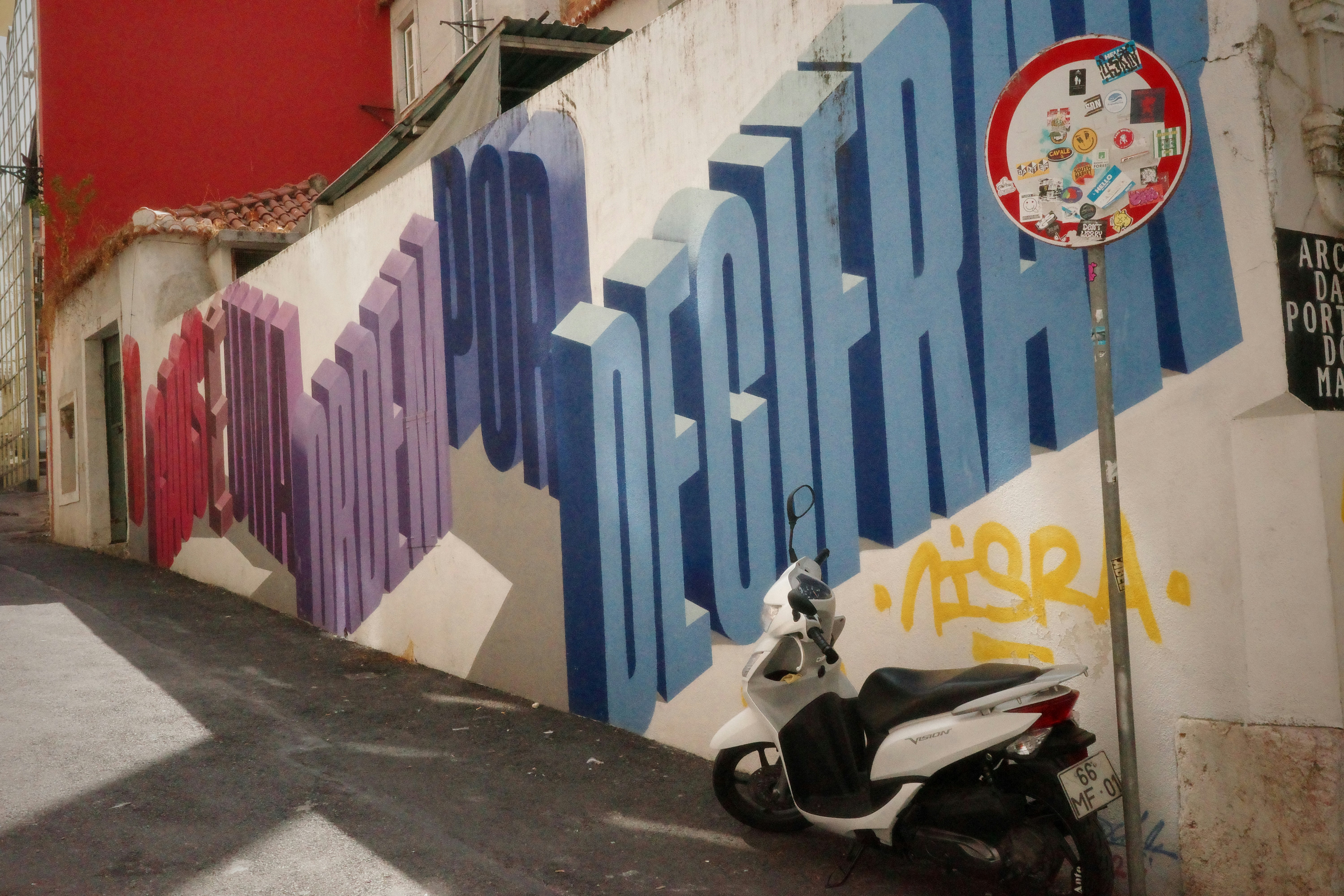 Graffiti art on a wall with a scooter nearby