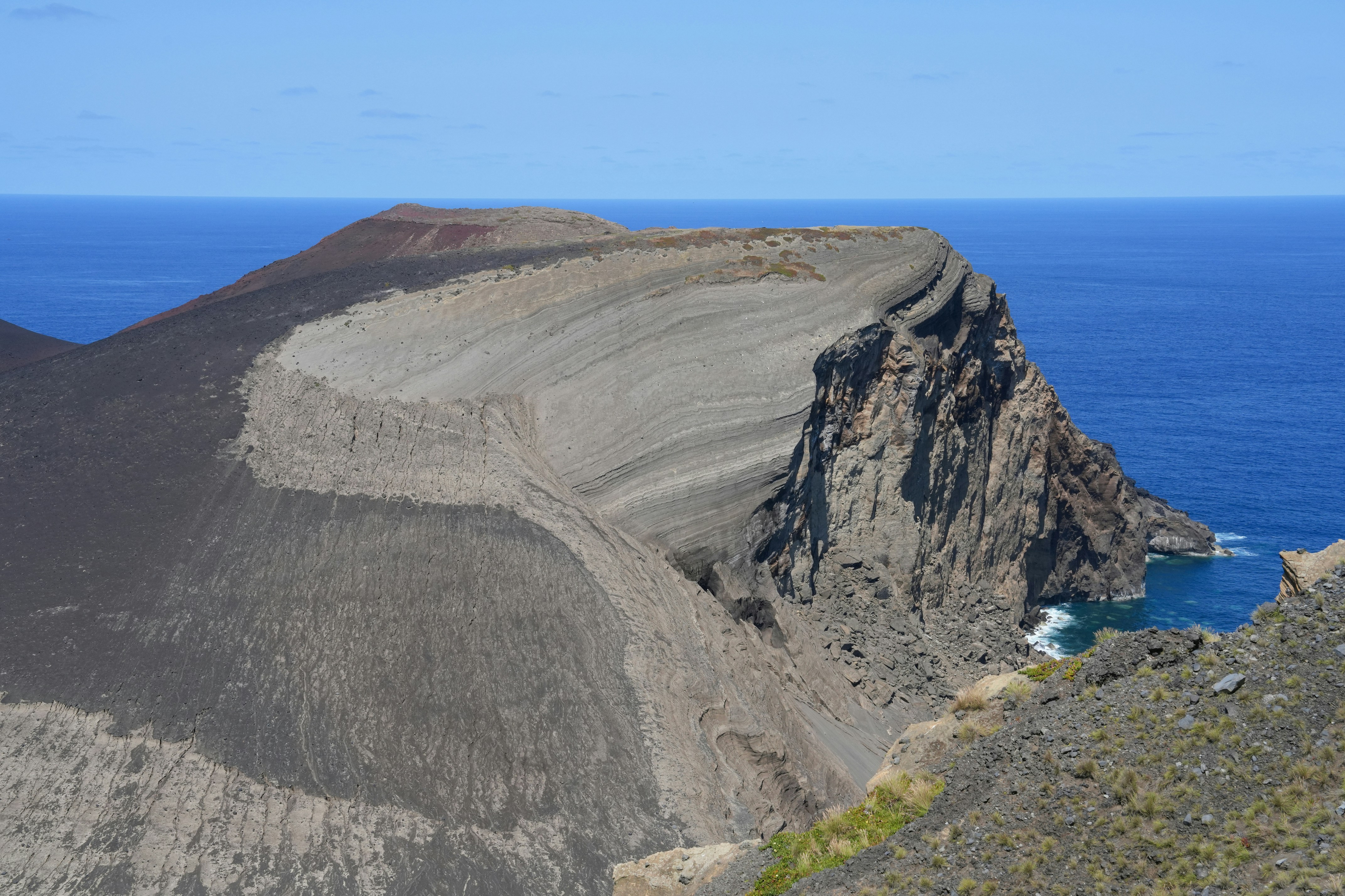 Volcanic crater overlooking the deep blue sea.