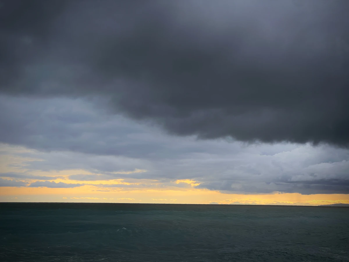 Dark storm clouds gathering low over the ocean horizon, representing the tropical systems Barbados watches every hurricane season