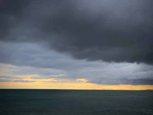 Dark storm clouds gathering over the ocean horizon