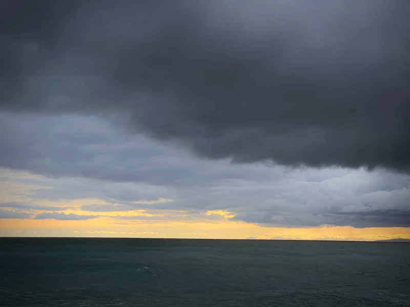 Dark storm clouds gathering low over the ocean horizon, representing the tropical systems Barbados watches every hurricane season