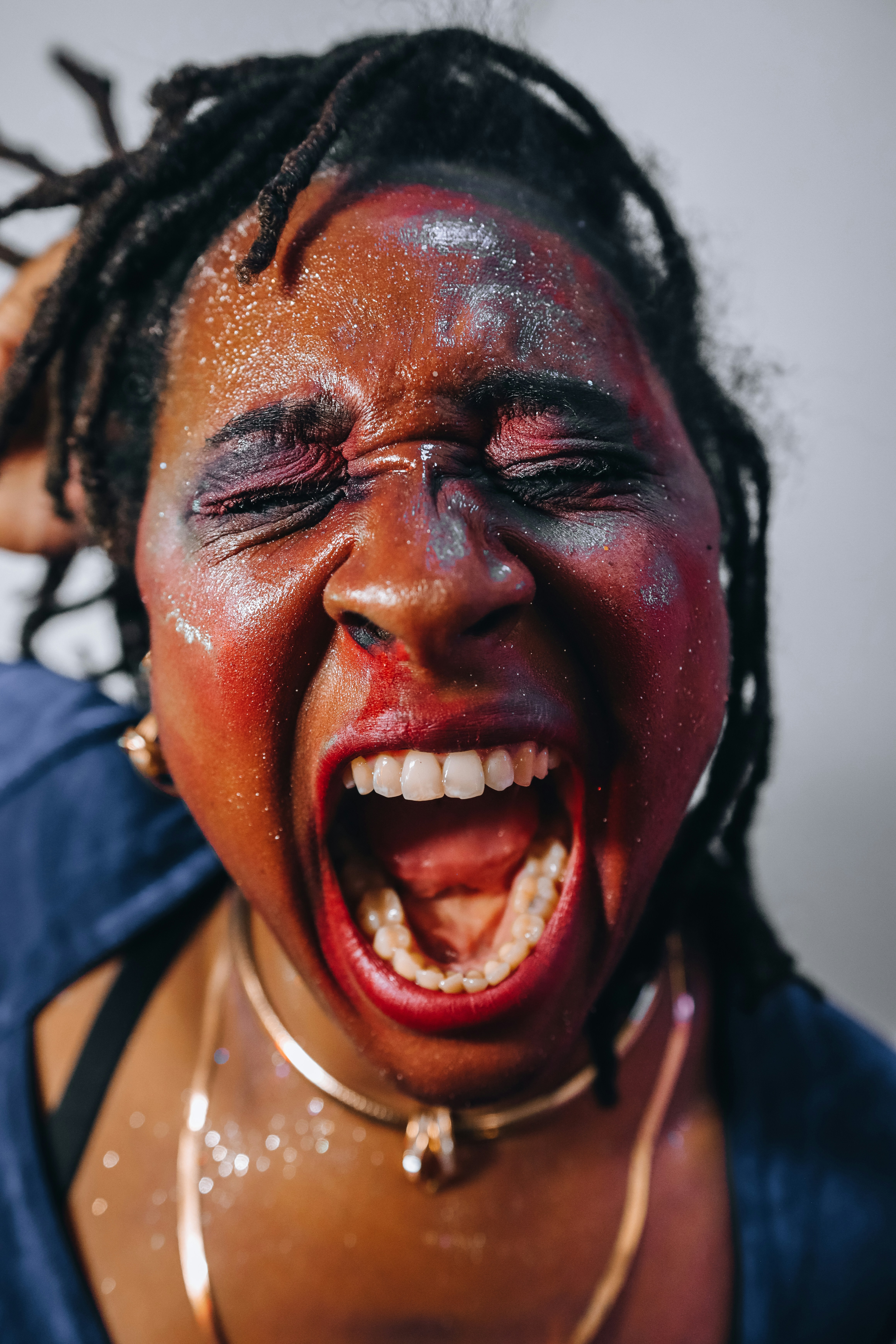 Wanita dengan glitter dan riasan merah berteriak