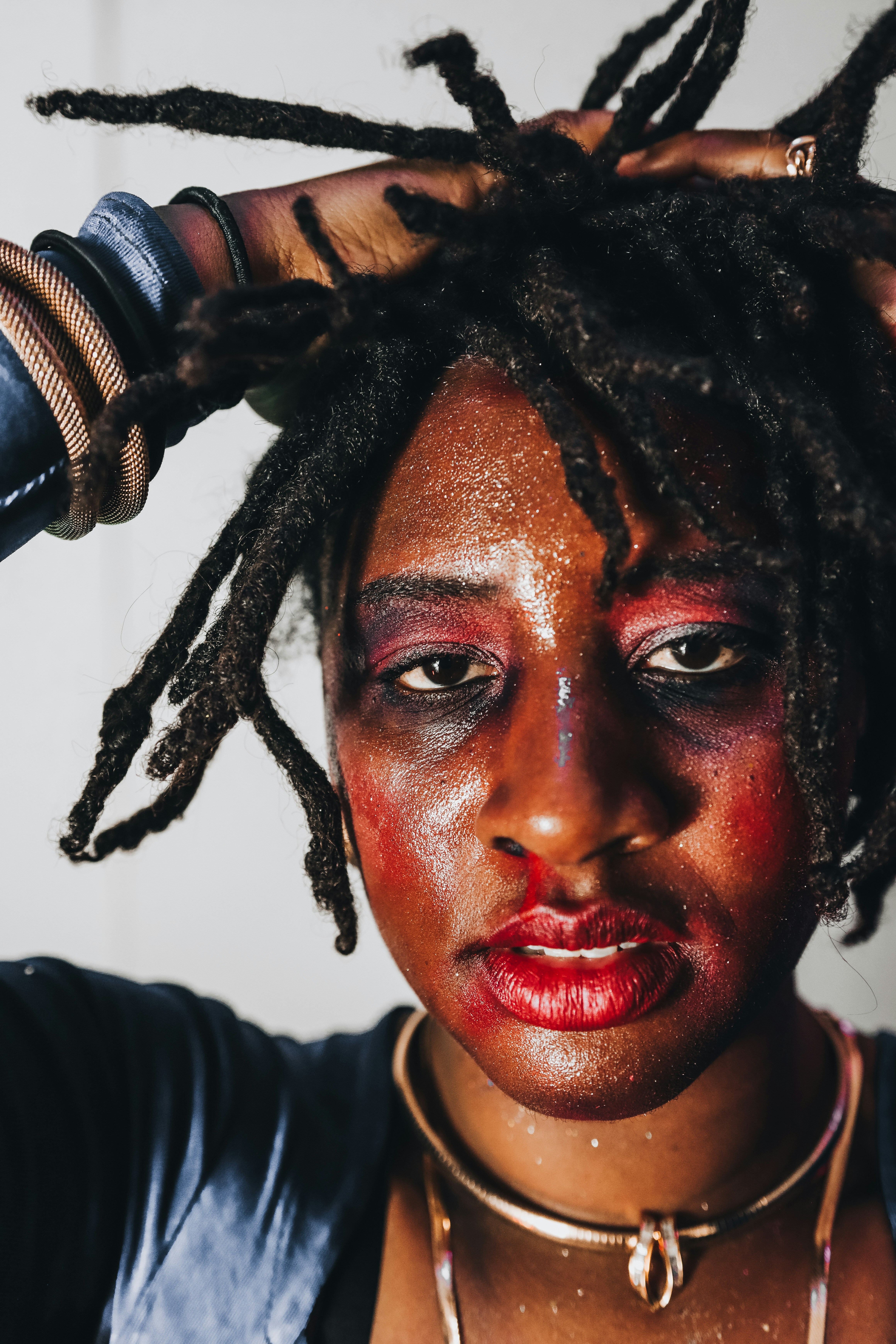 Mujer con rastas y poses dramáticas de maquillaje