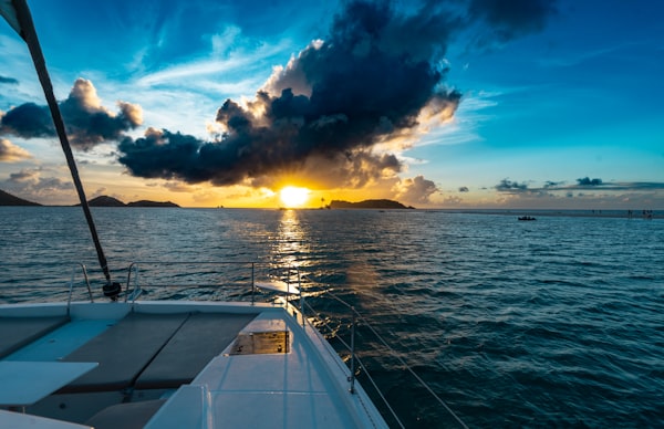 Catamaran deck sailing toward a vibrant Caribbean sunset near Isla Mujeres Cancun