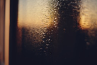 Water droplets on glass with blurred sunset background