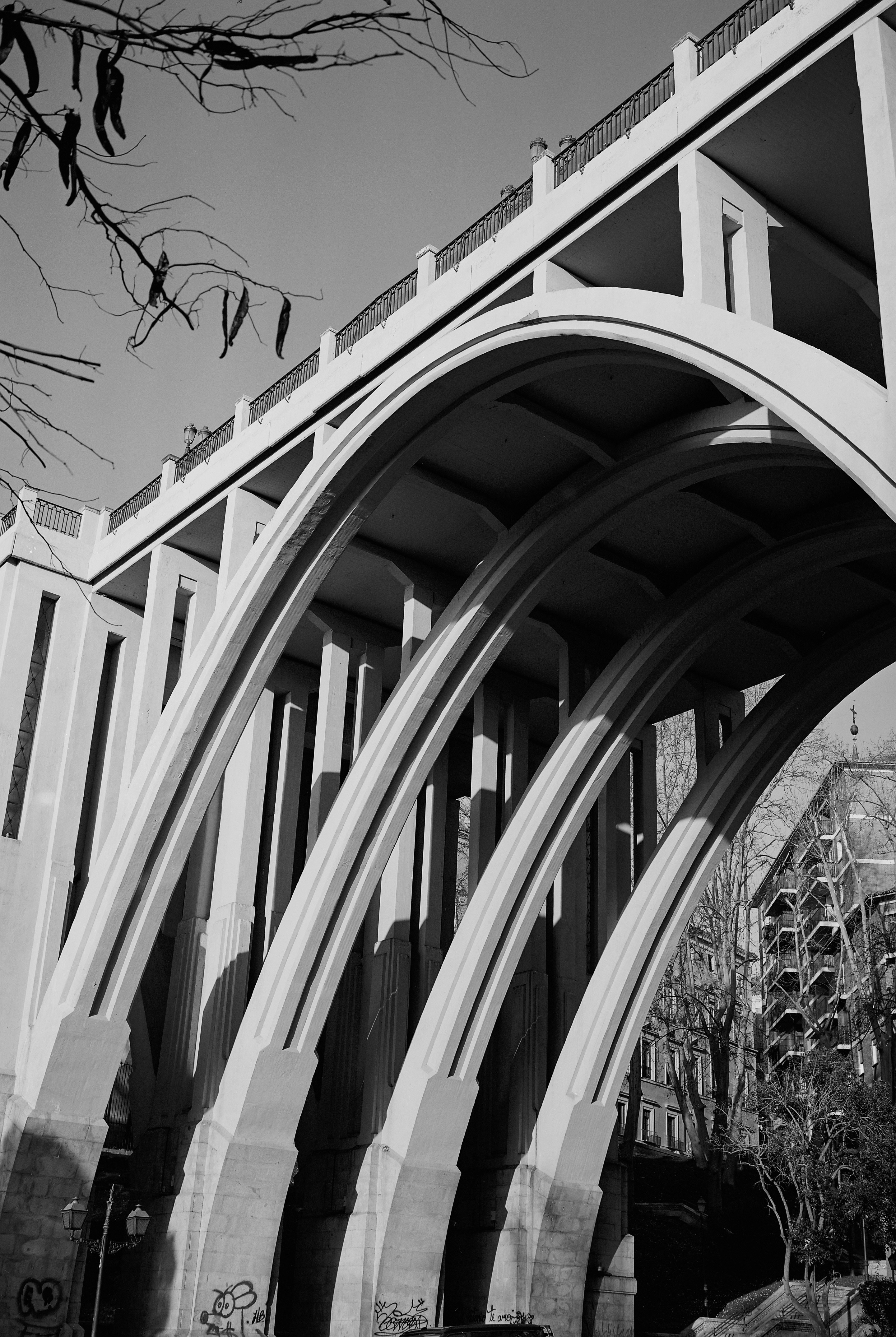 Arched concrete bridge structure with shadows.