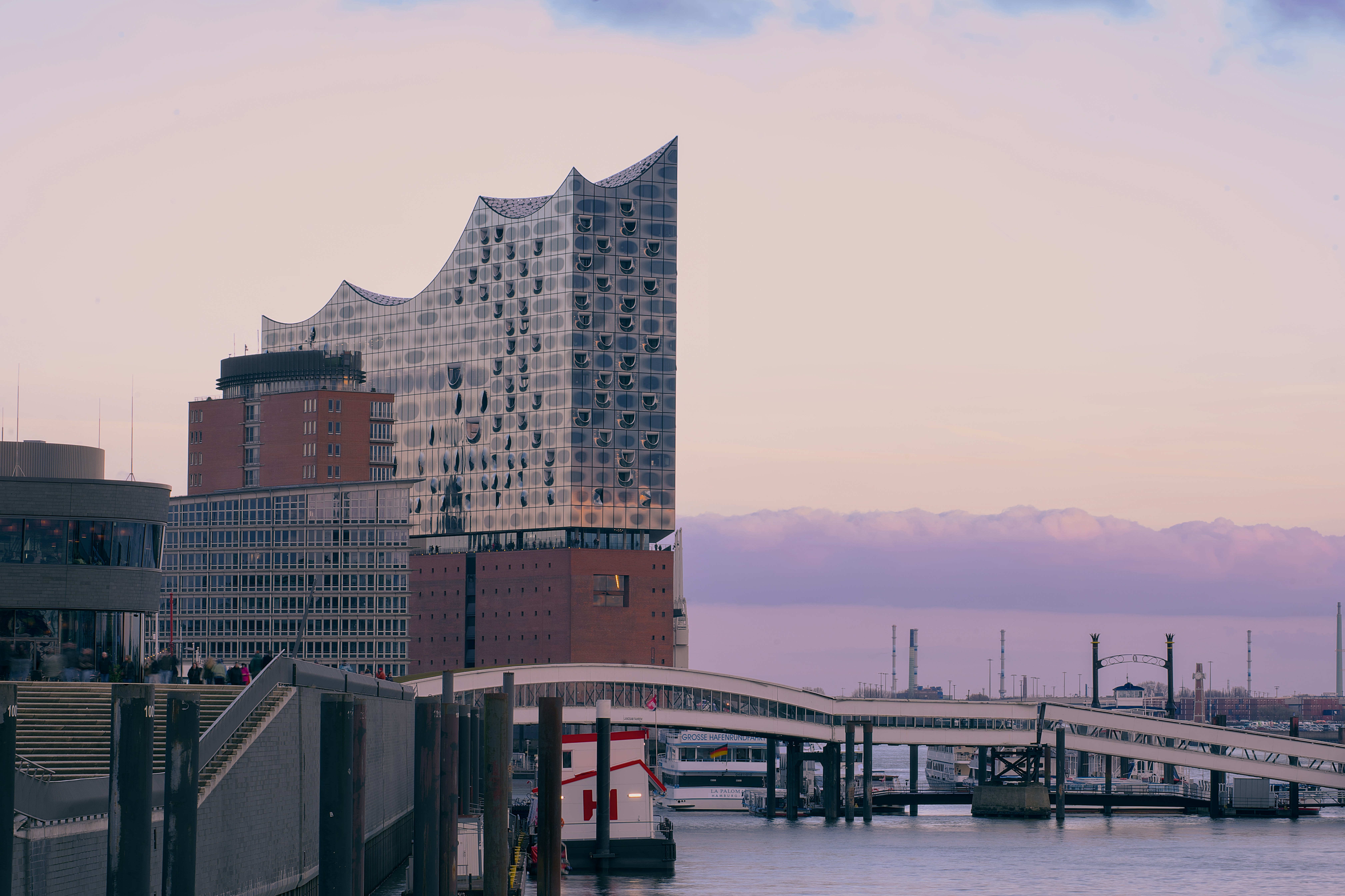 Edificio moderno junto al agua al atardecer.