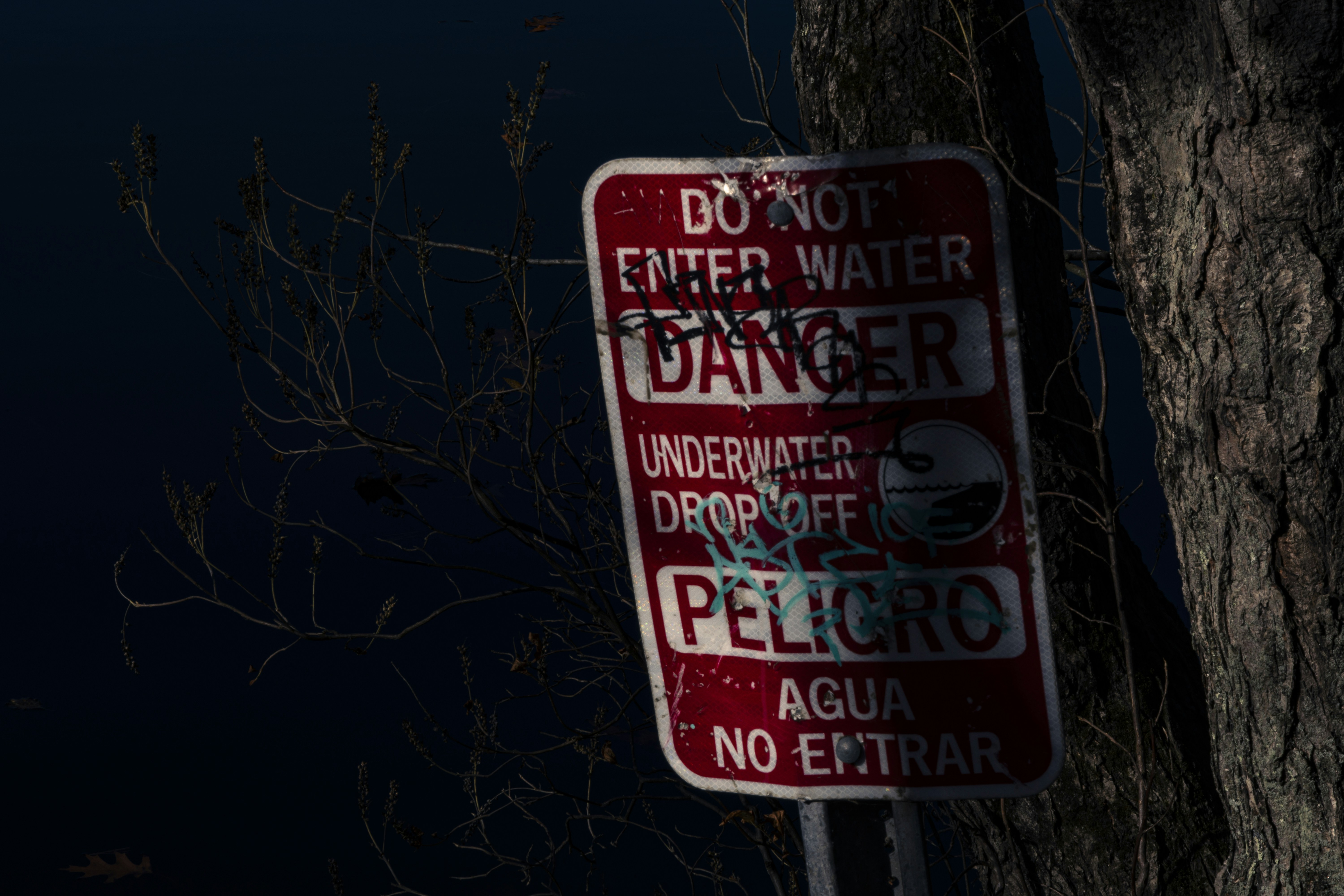 Red danger sign warning about water and drop-off.