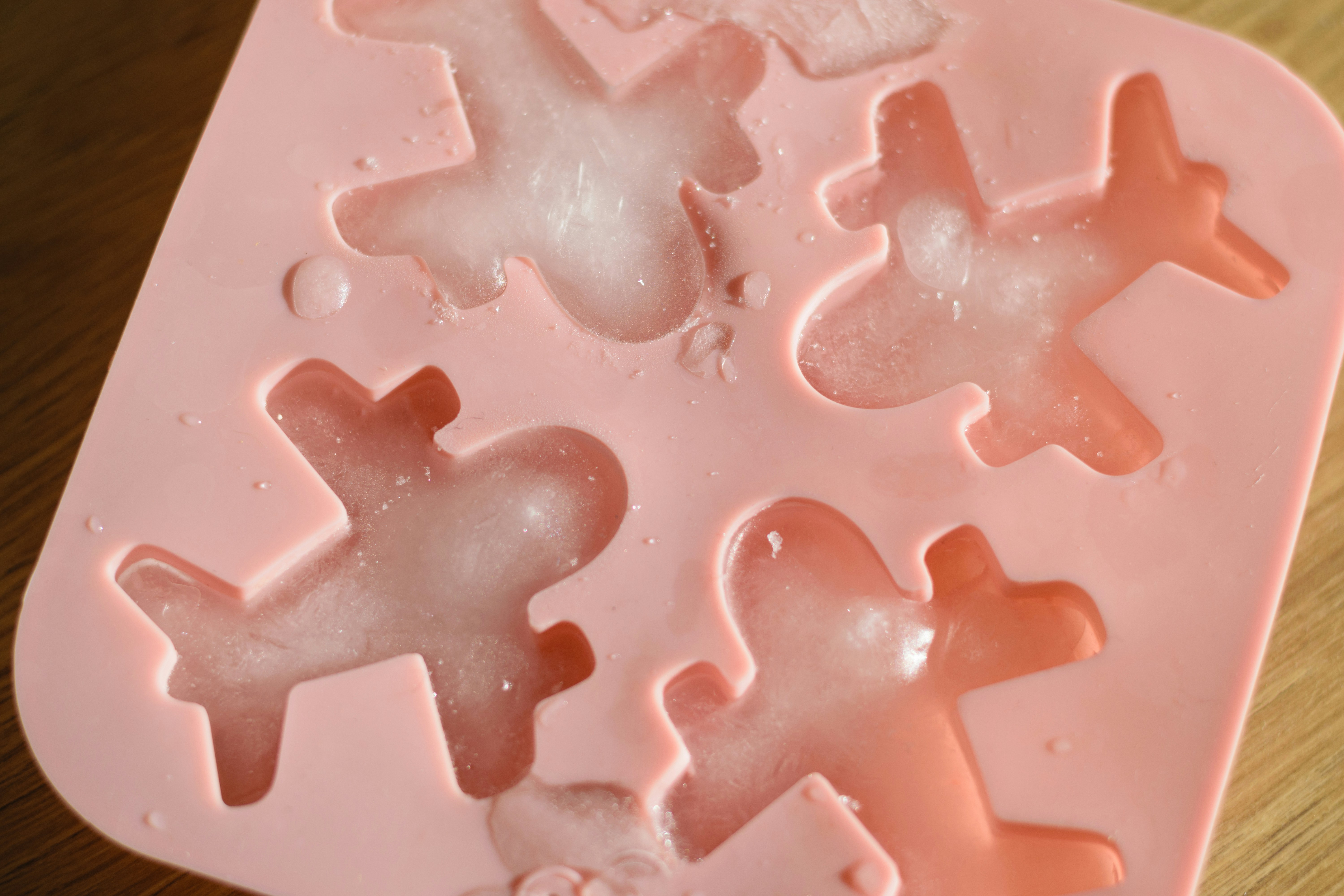 Airplane shaped ice cubes in a pink mold