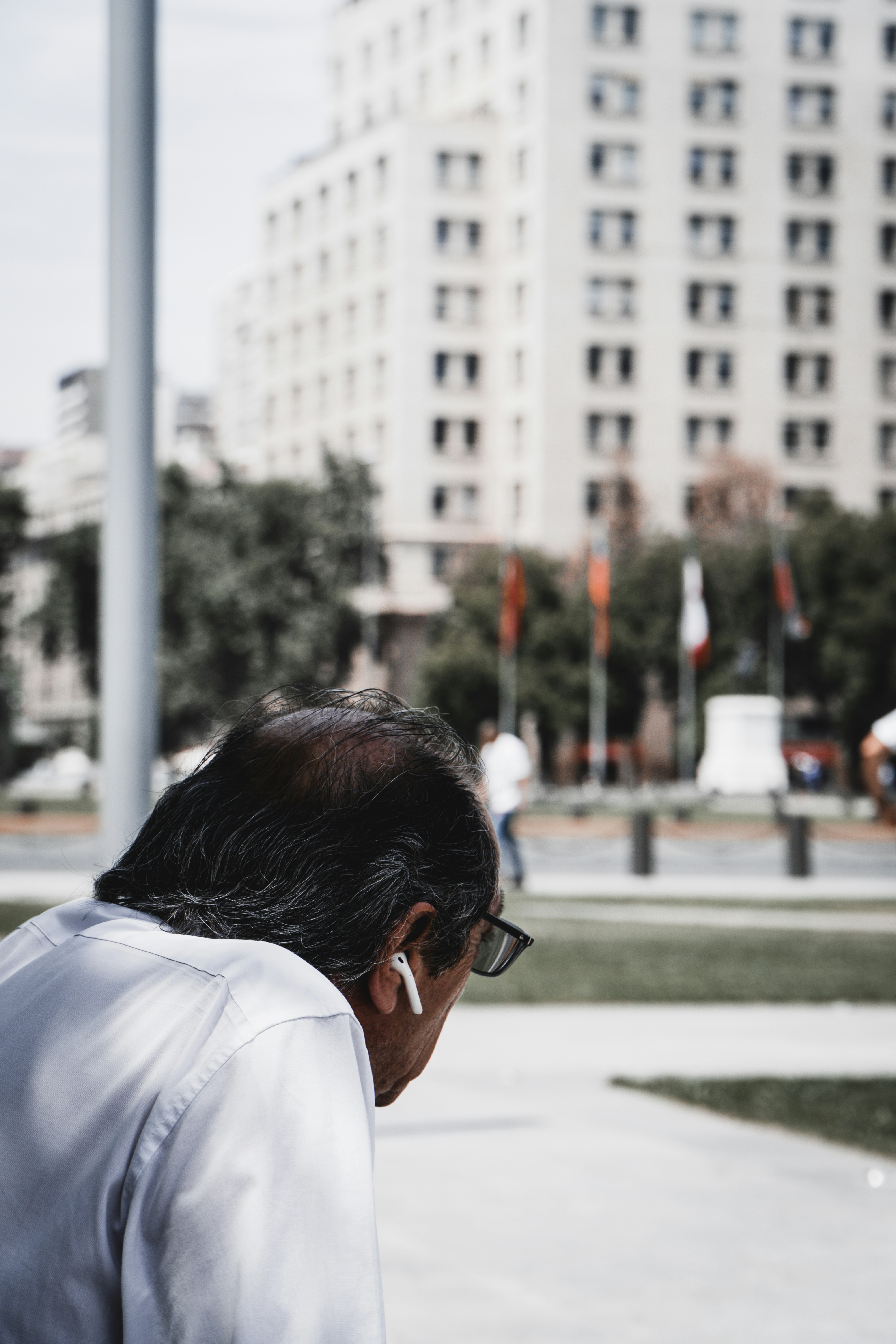 Man with earbuds in front of a building