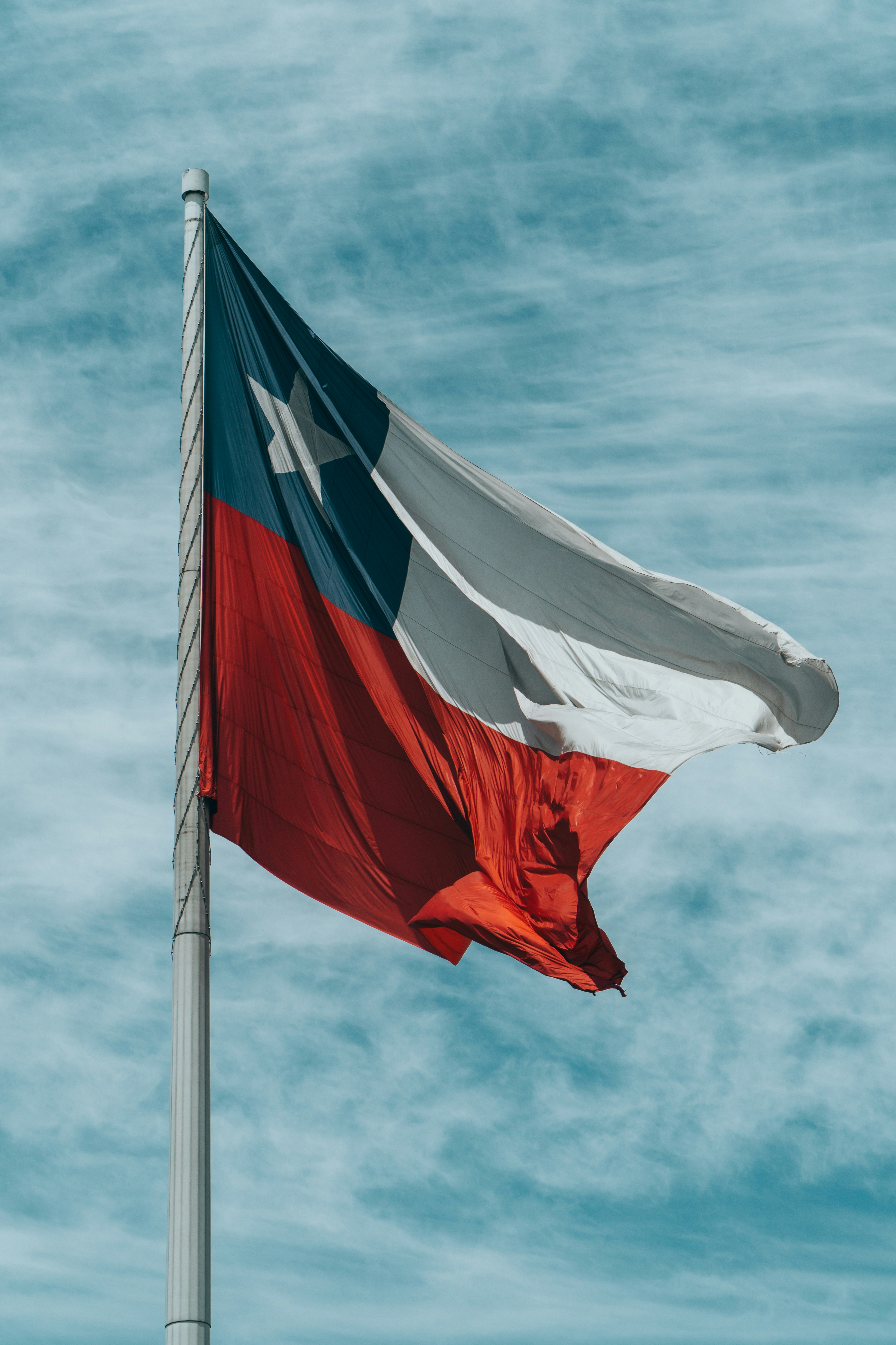 Chilean flag waving against a cloudy blue sky