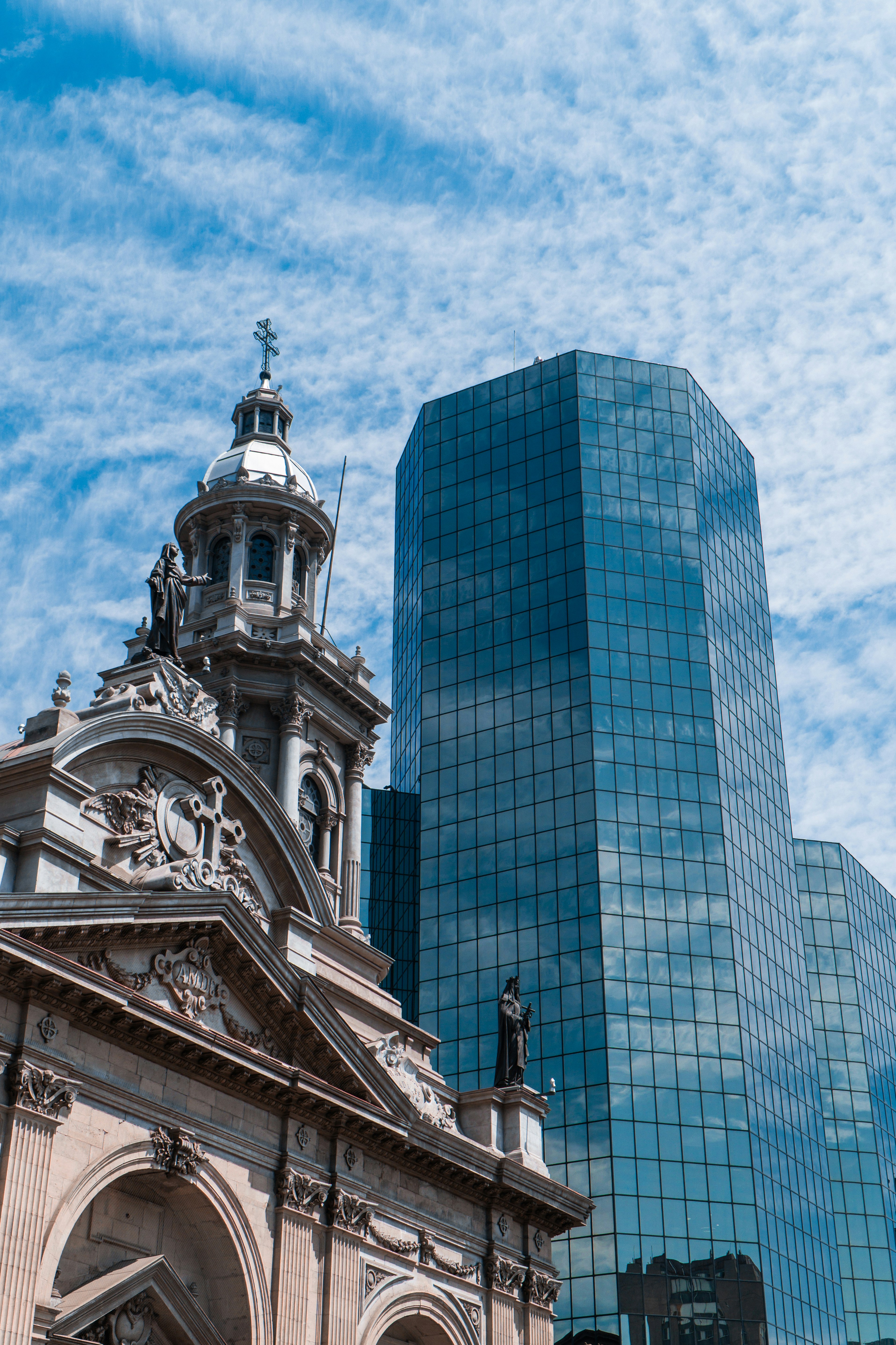 Historic church facade next to modern glass skyscraper