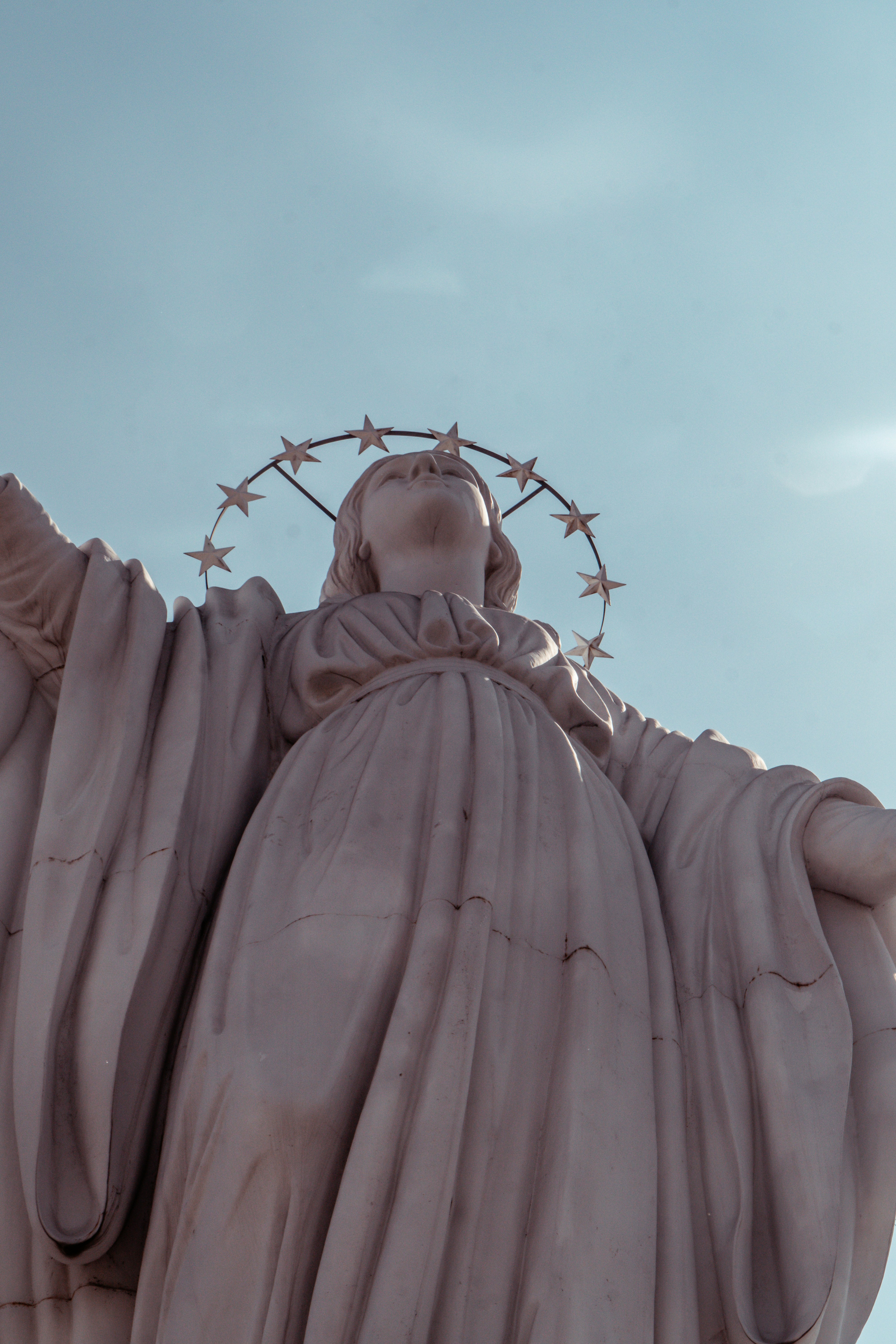 A marble statue of a woman with outstretched arms.