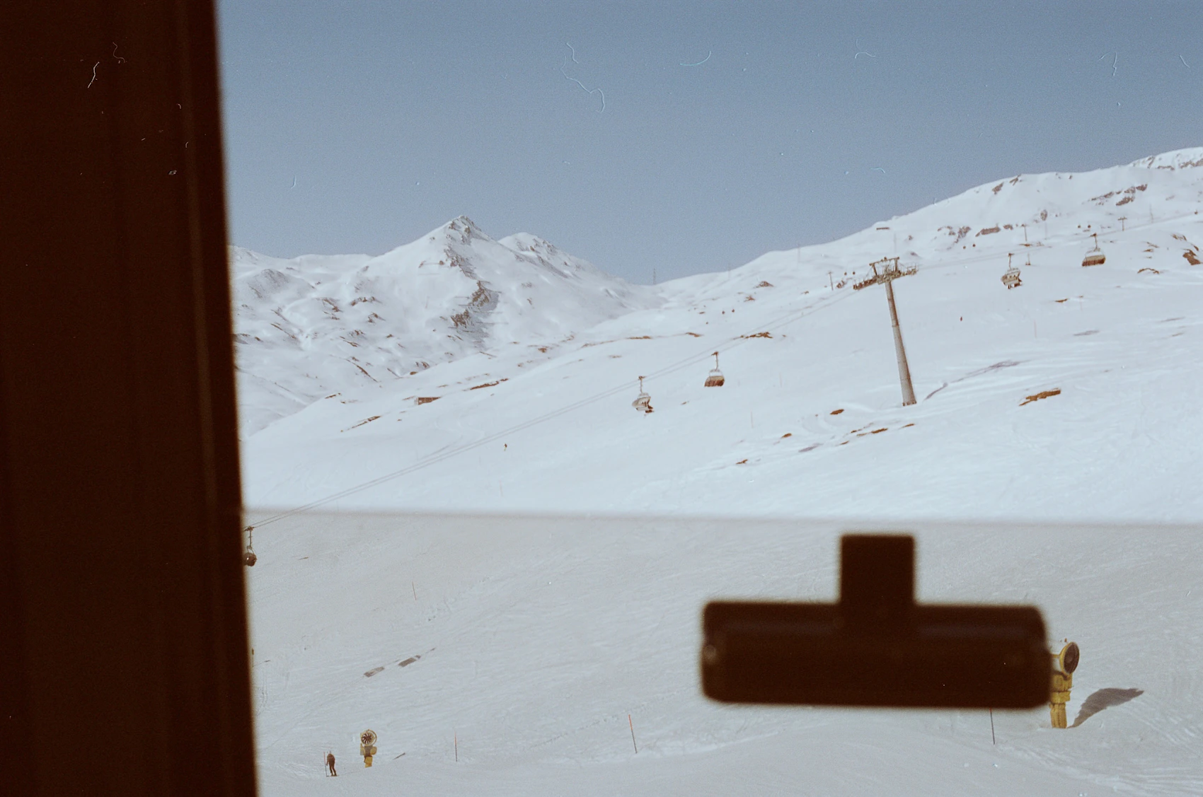 Skiers and a lift among high snowy mountains