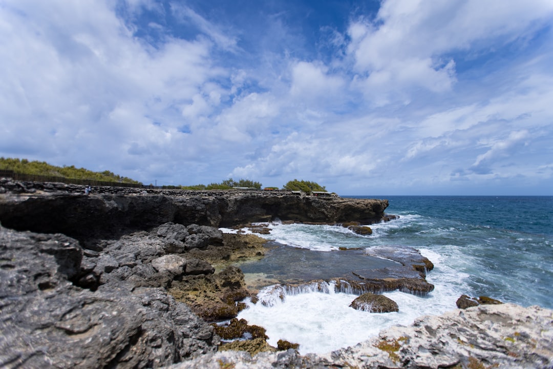 Rocky coastline with waves crashing under a cloudy sky
